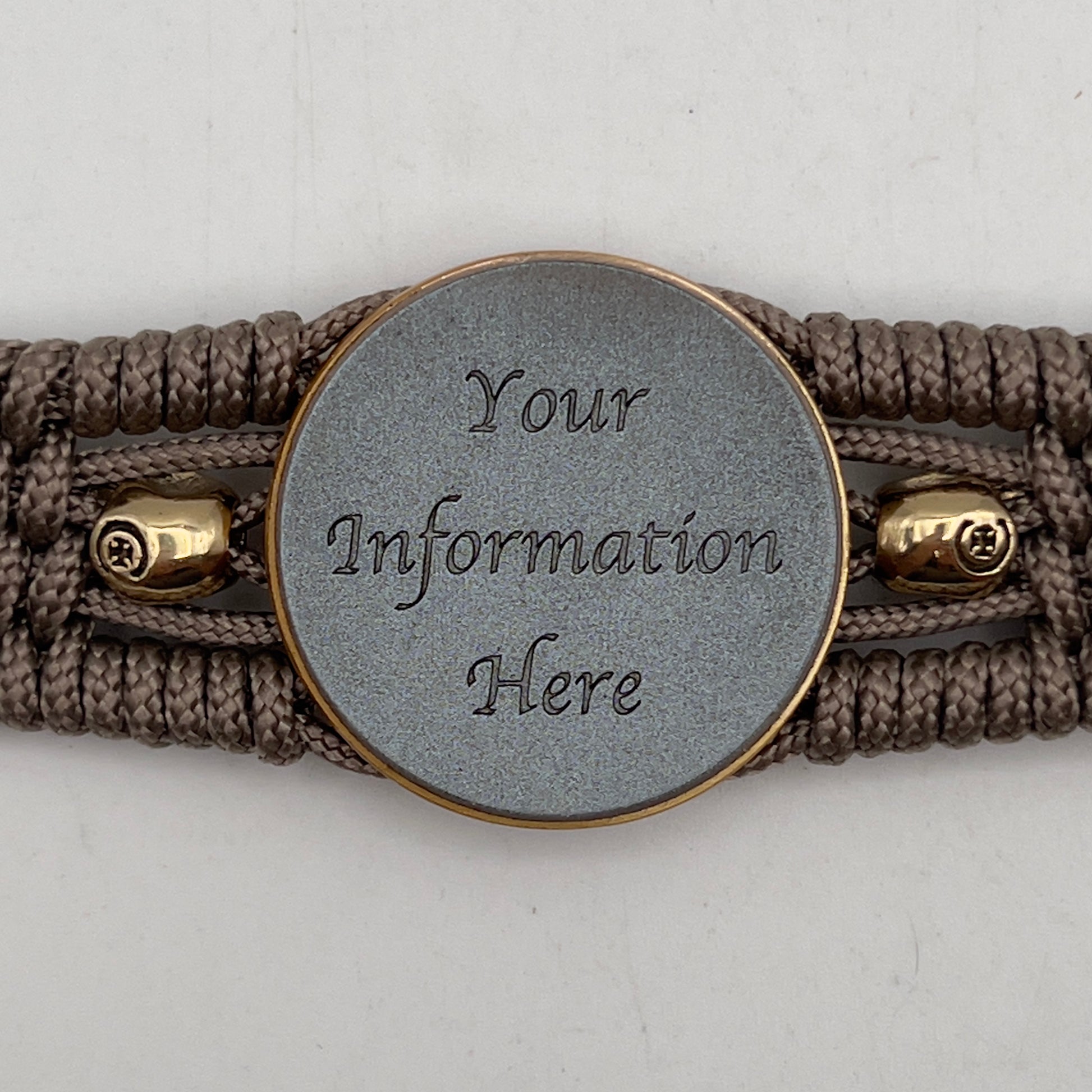 Thin, medium width, flexible and comfortable braided United States Marine Corps bracelet featuring a 24K antique gold plated USMC officer Eagle Globe and Anchor medallion, two gold plated skulls, a gold Cobra style tactical buckle and woven with tan Type-1 paracord.