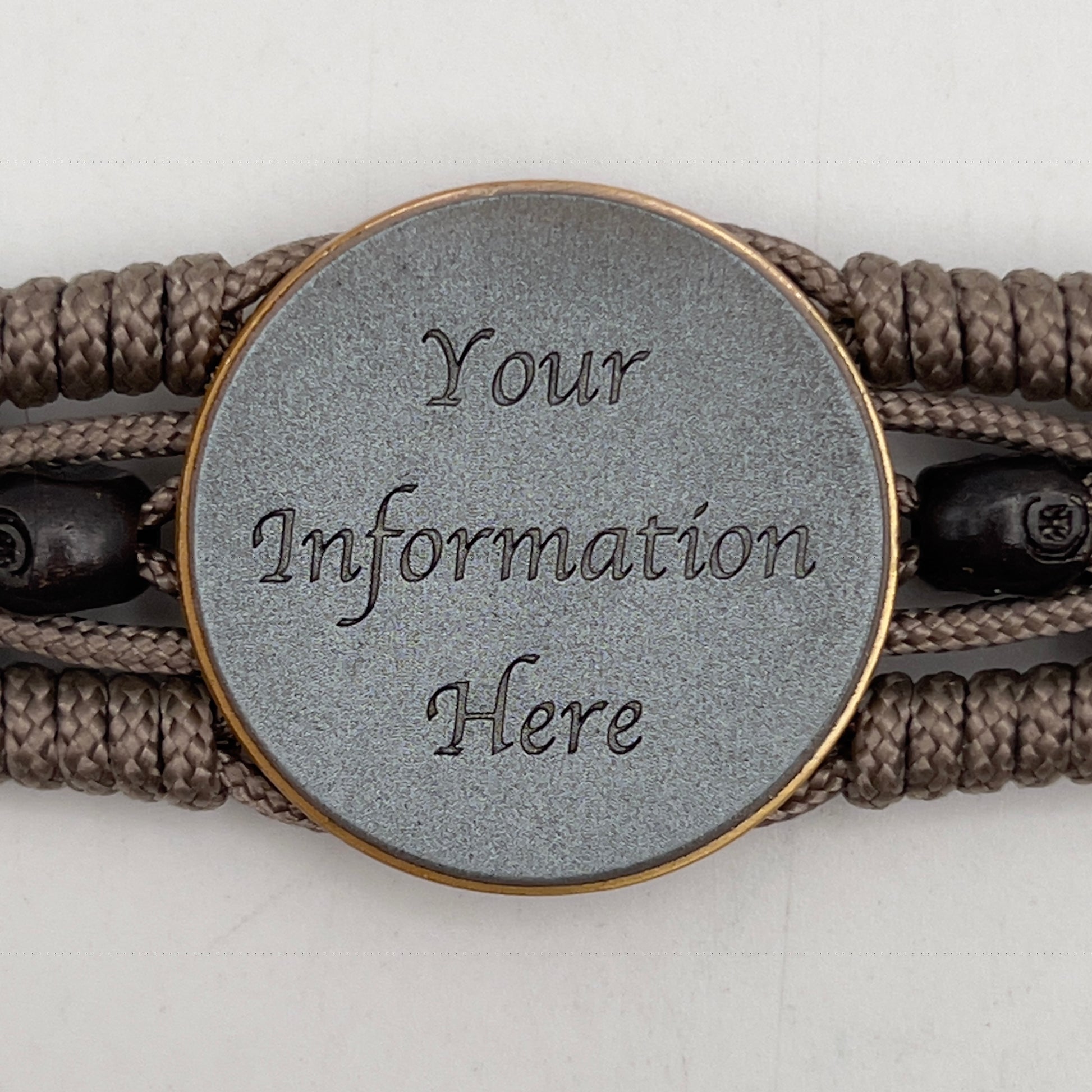 Thin, medium width, flexible and comfortable braided United States Marine Corps bracelet featuring a 24K antique gold plated USMC officer Eagle Globe and Anchor medallion, two black skulls, a black Cobra style tactical buckle and woven with tan Type-1 paracord.