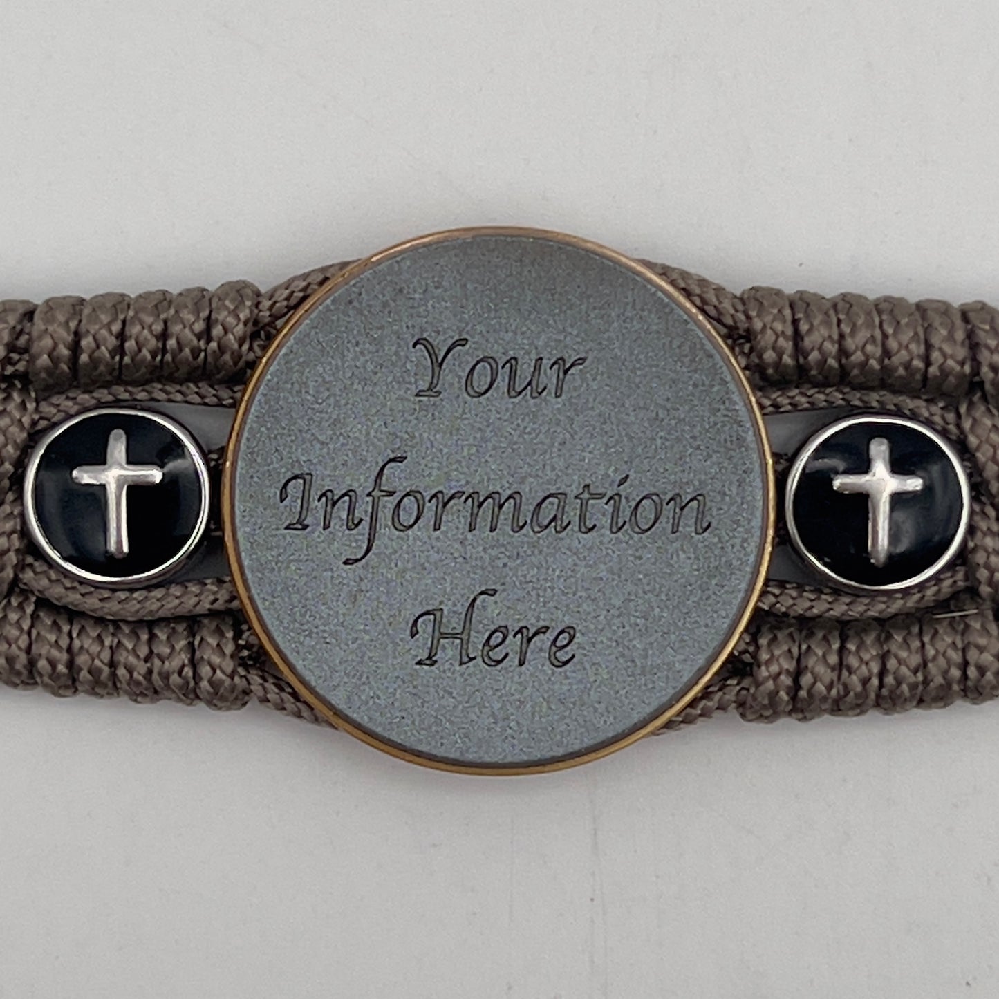 Thin, medium width, flexible and comfortable braided United States Marine Corps bracelet featuring a 24K antique gold plated USMC officer Eagle Globe and Anchor medallion, two Christian crosses, a black Cobra style tactical buckle and woven with Tan Type-1 paracord.