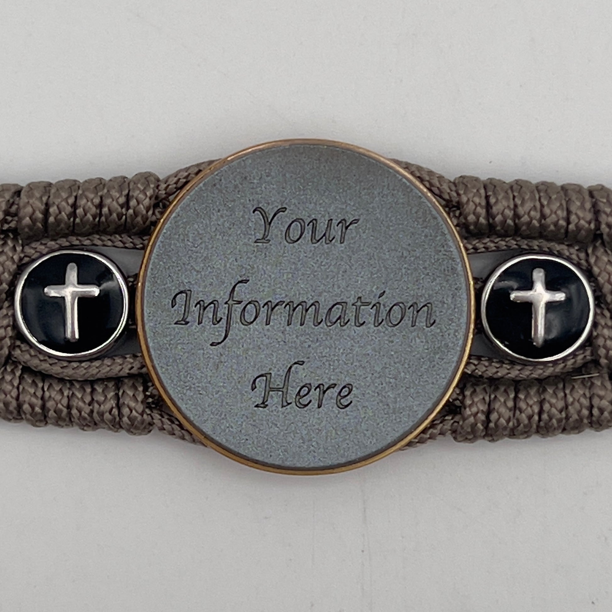 Thin, medium width, flexible and comfortable braided United States Marine Corps bracelet featuring a 24K antique gold plated USMC officer Eagle Globe and Anchor medallion, two Christian crosses, a black Cobra style tactical buckle and woven with Tan Type-1 paracord.