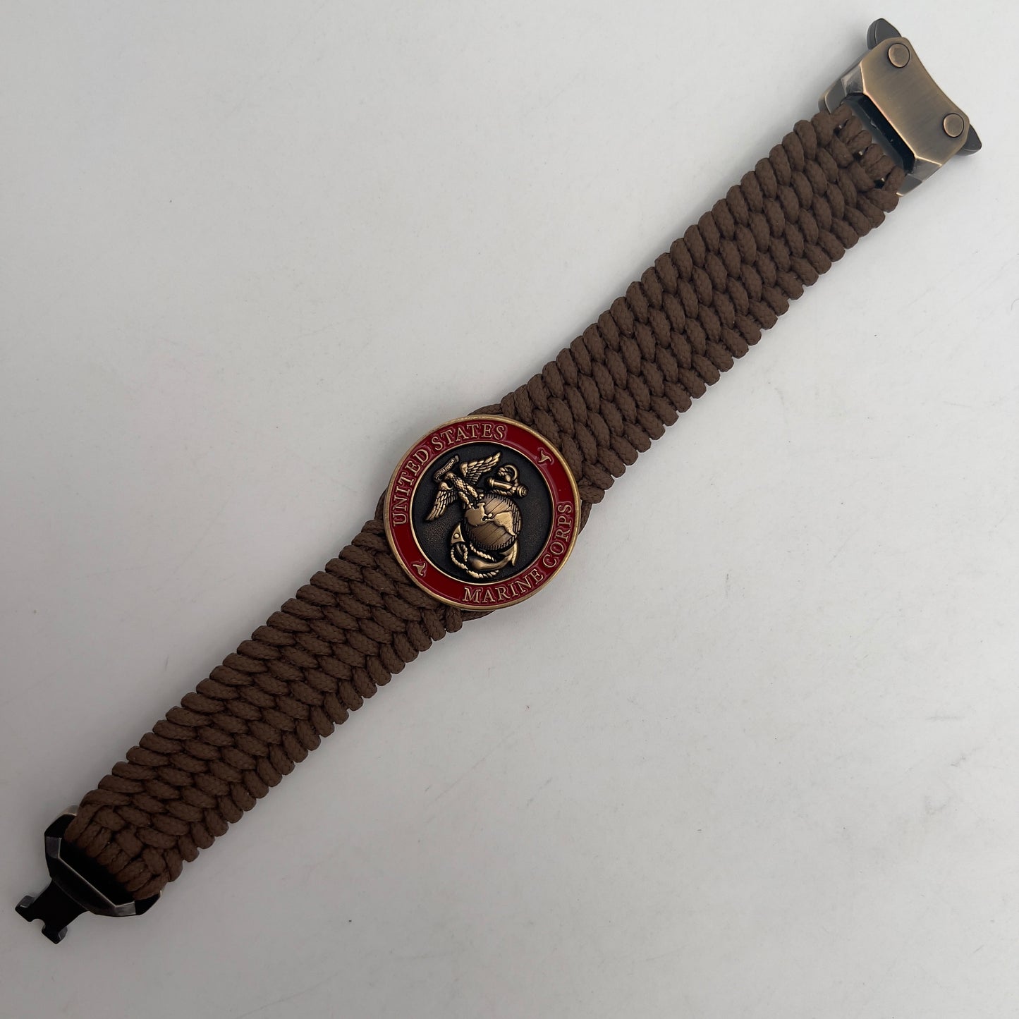 Thin, medium wide, flexible and comfortable braided United States Marine Corps bracelet featuring a 24K antique gold plated USMC Eagle Globe and Anchor medallion, a gold Cobra style tactical buckle and woven with Coyote Brown Type-1 paracord.