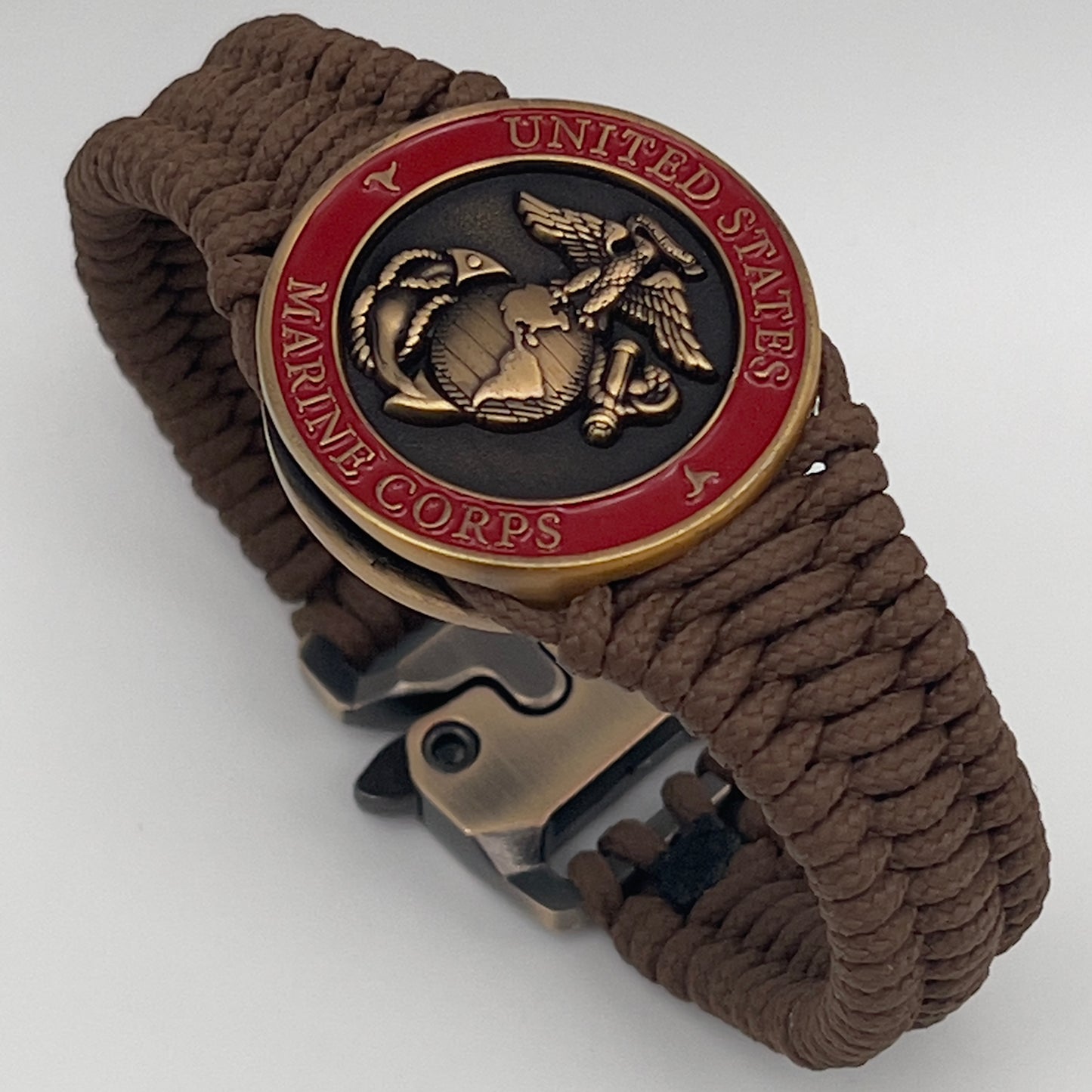 Thin, narrow, flexible and comfortable braided United States Marine Corps bracelet featuring a 24K antique gold plated USMC Eagle Globe and Anchor medallion, a gold Cobra style tactical buckle and woven with Coyote Brown Type-1 paracord.