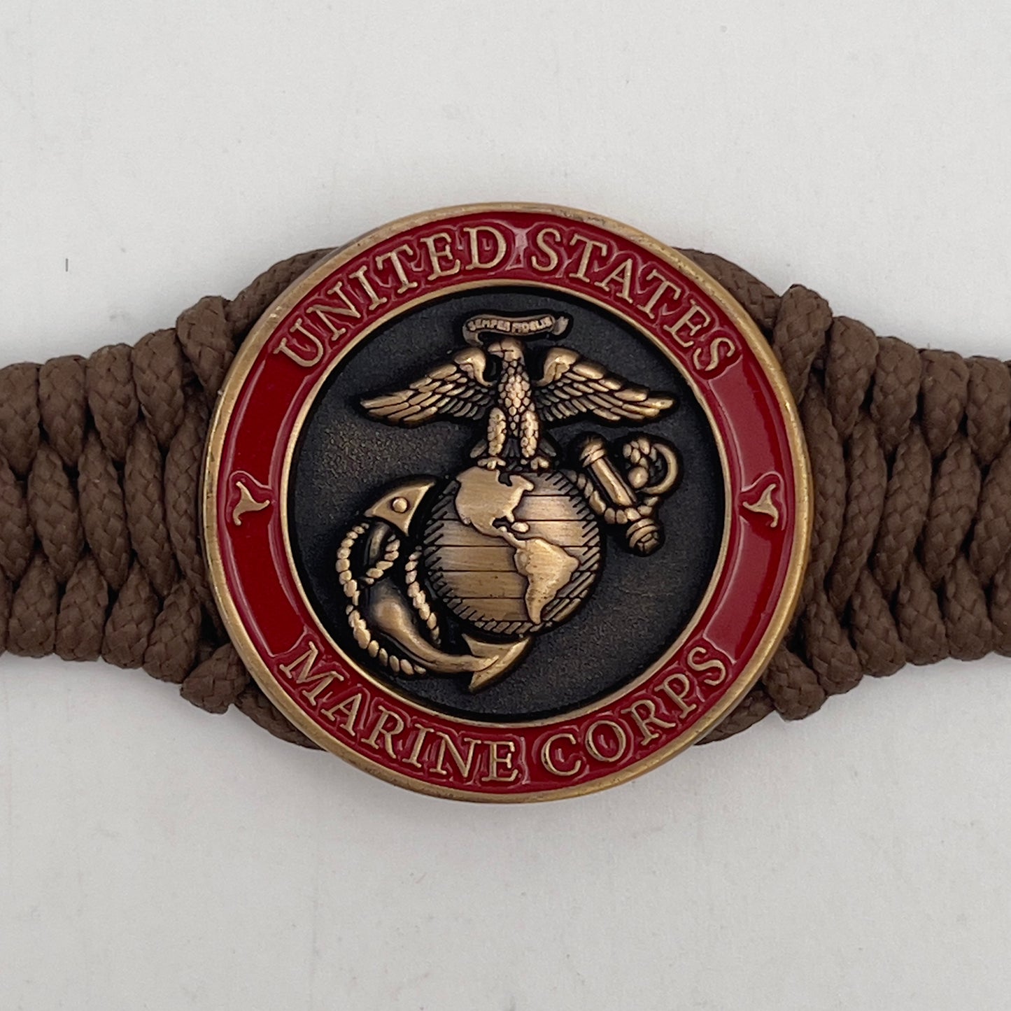 Thin, narrow, flexible and comfortable braided United States Marine Corps bracelet featuring a 24K antique gold plated USMC Eagle Globe and Anchor medallion, a gold Cobra style tactical buckle and woven with Coyote Brown Type-1 paracord.