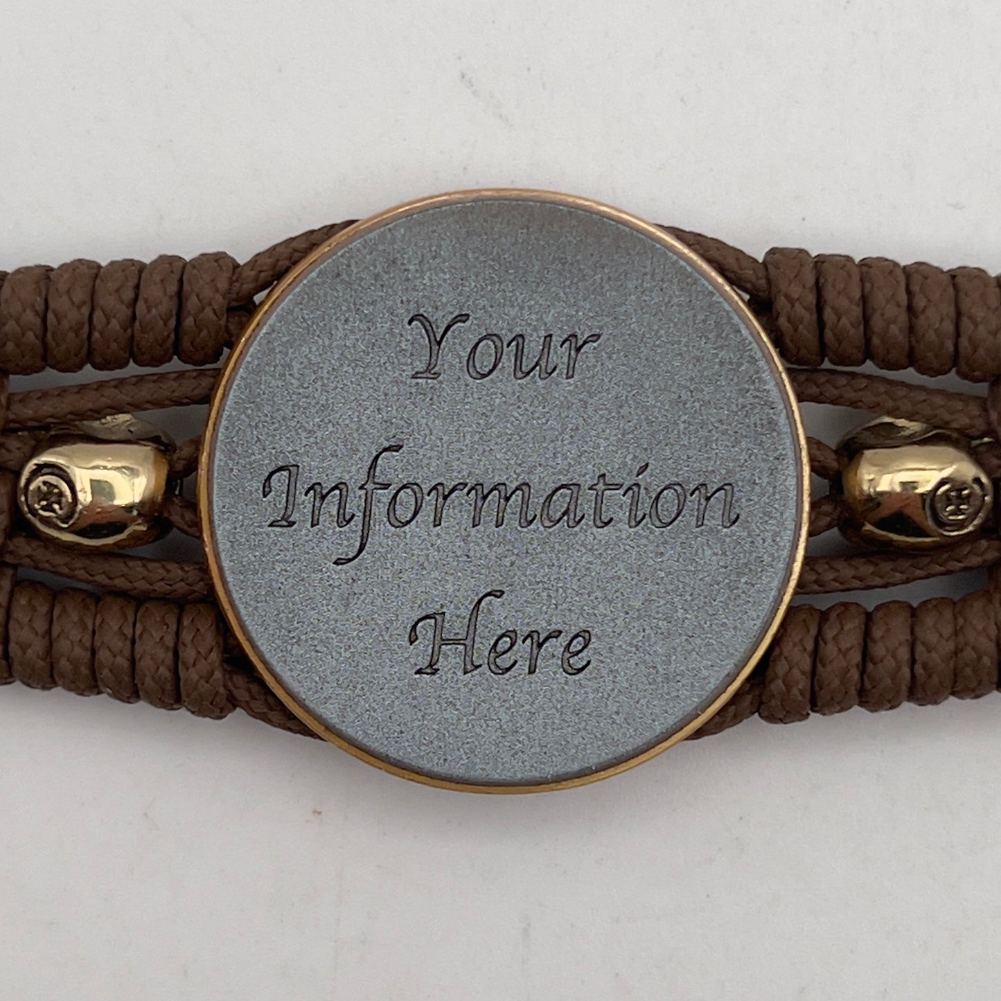 Thin, medium width, flexible and comfortable braided United States Marine Corps bracelet featuring a 24K antique gold plated USMC officer Eagle Globe and Anchor medallion, two gold plated skulls, a gold Cobra style tactical buckle and woven with Coyote Brown Type-1 paracord.