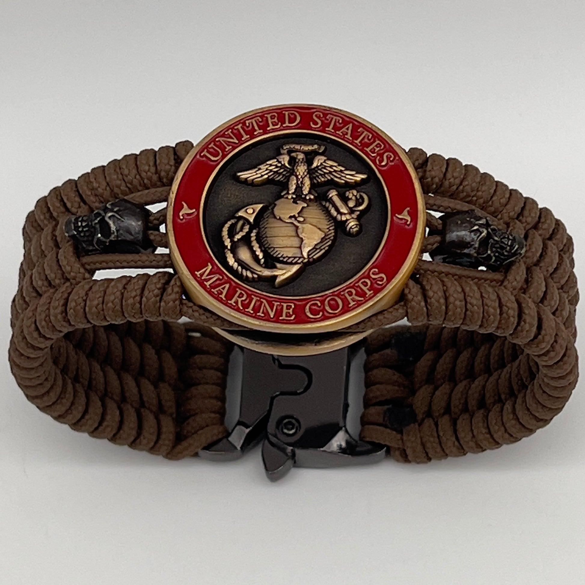 Thin, medium width, flexible and comfortable braided United States Marine Corps bracelet featuring a 24K antique gold plated USMC officer Eagle Globe and Anchor medallion, two black skulls, a black Cobra style tactical buckle and woven with Coyote Brown Type-1 paracord.