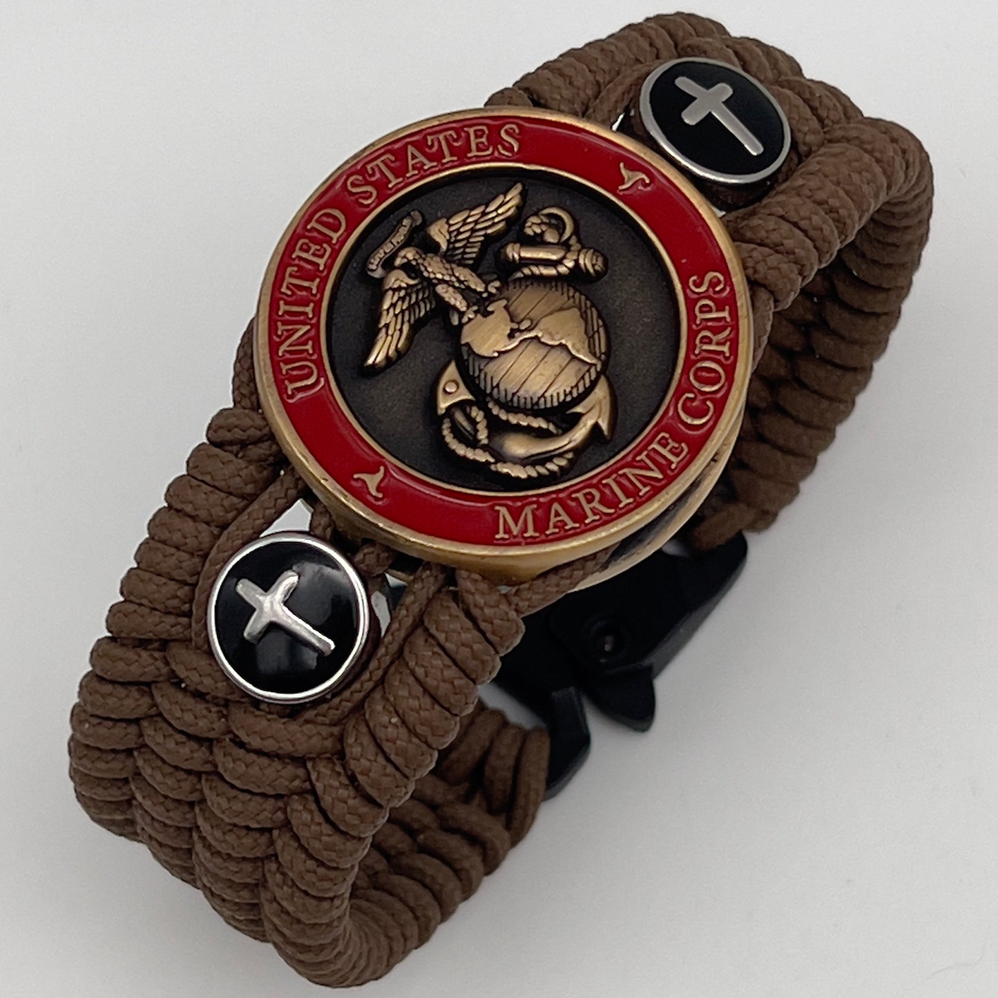 Thin, medium width, flexible and comfortable braided United States Marine Corps bracelet featuring a 24K antique gold plated USMC officer Eagle Globe and Anchor medallion, two Christian crosses, a black Cobra style tactical buckle and woven with Coyote Brown Type-1 paracord.