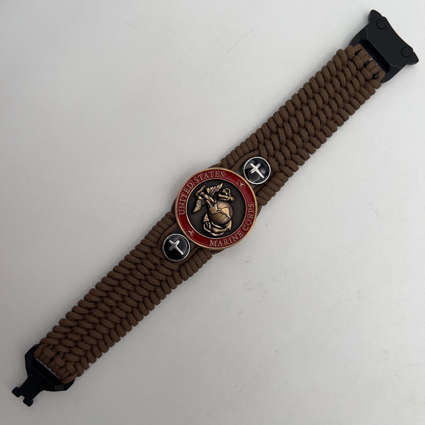 Thin, medium width, flexible and comfortable braided United States Marine Corps bracelet featuring a 24K antique gold plated USMC officer Eagle Globe and Anchor medallion, two Christian crosses, a black Cobra style tactical buckle and woven with Coyote Brown Type-1 paracord.