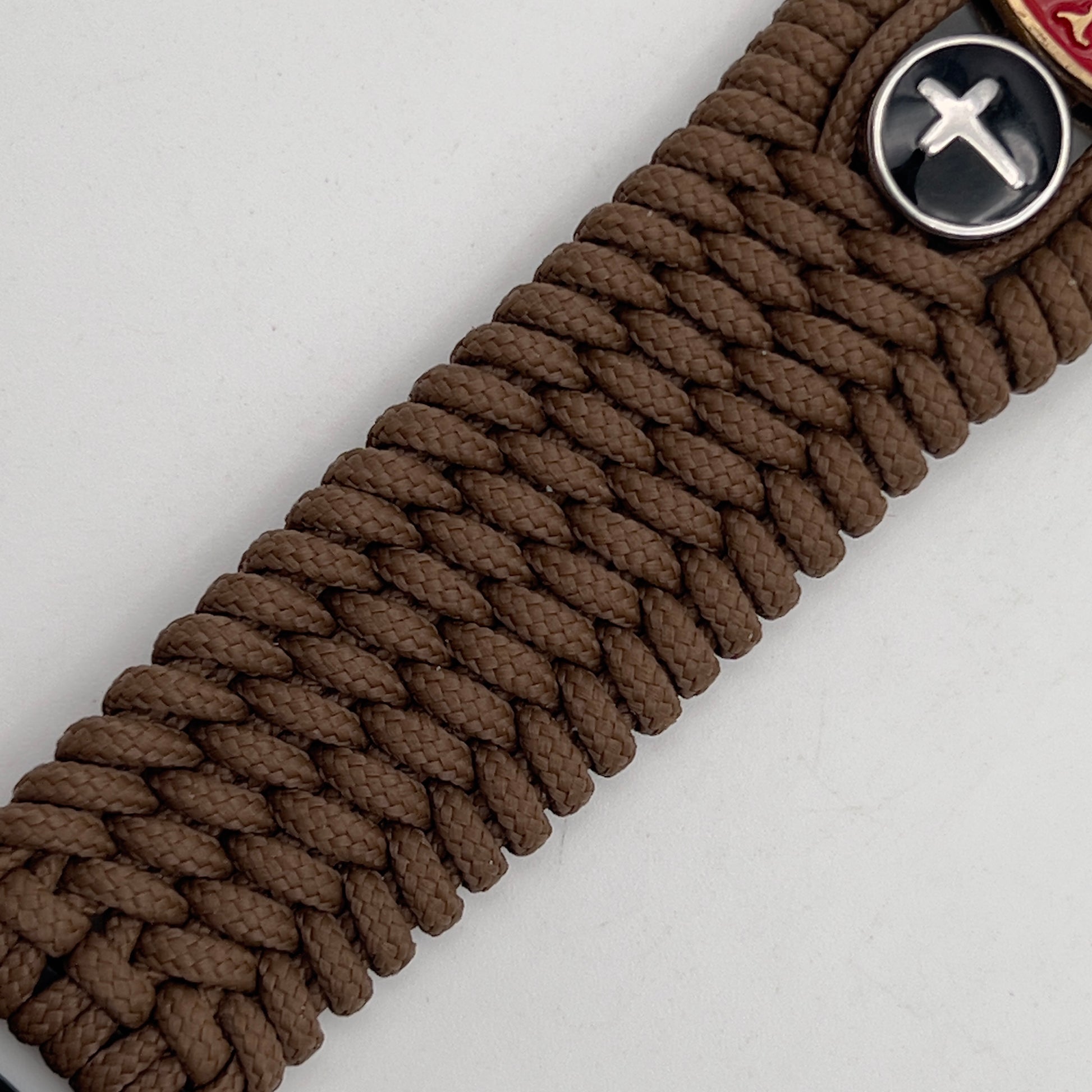 Thin, medium width, flexible and comfortable braided United States Marine Corps bracelet featuring a 24K antique gold plated USMC officer Eagle Globe and Anchor medallion, two Christian crosses, a black Cobra style tactical buckle and woven with Coyote Brown Type-1 paracord.