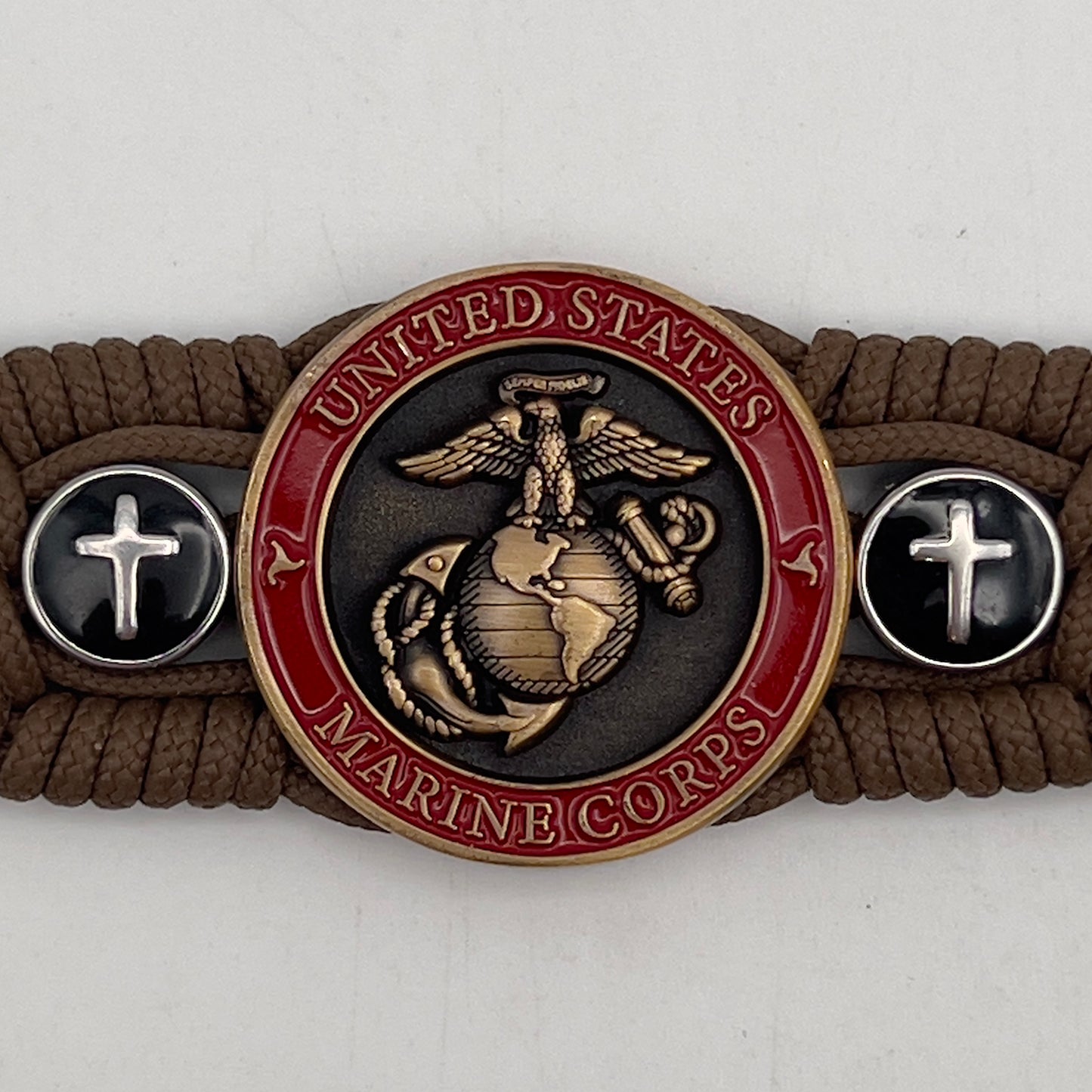 Thin, medium width, flexible and comfortable braided United States Marine Corps bracelet featuring a 24K antique gold plated USMC officer Eagle Globe and Anchor medallion, two Christian crosses, a black Cobra style tactical buckle and woven with Coyote Brown Type-1 paracord.