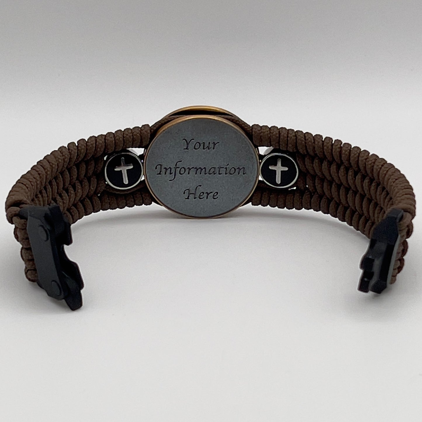 Thin, medium width, flexible and comfortable braided United States Marine Corps bracelet featuring a 24K antique gold plated USMC officer Eagle Globe and Anchor medallion, two Christian crosses, a black Cobra style tactical buckle and woven with Coyote Brown Type-1 paracord.
