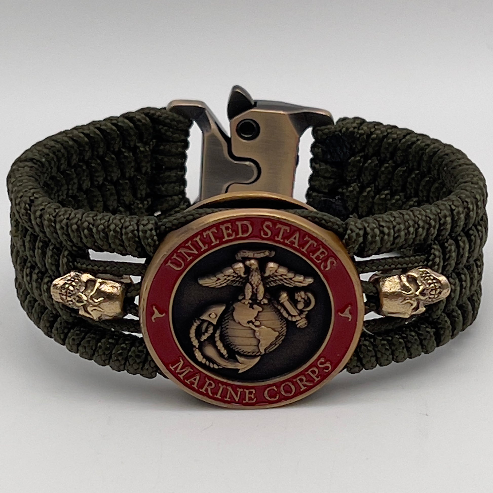 Thin, medium width, flexible and comfortable braided United States Marine Corps bracelet featuring a 24K antique gold plated USMC officer Eagle Globe and Anchor medallion, two gold plated skulls, a gold Cobra style tactical buckle and woven with Olive Drab Type-1 paracord.