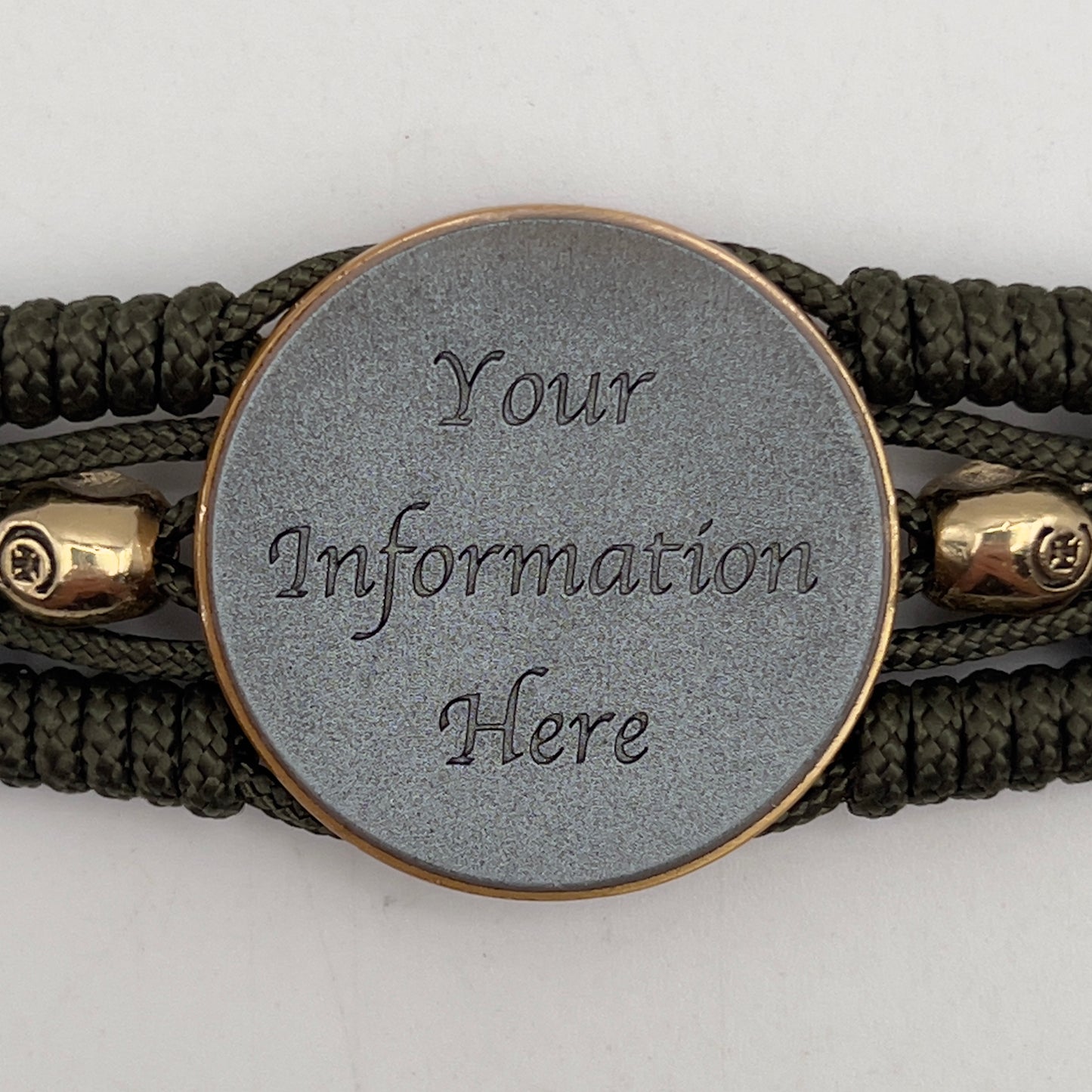 Thin, medium width, flexible and comfortable braided United States Marine Corps bracelet featuring a 24K antique gold plated USMC officer Eagle Globe and Anchor medallion, two gold plated skulls, a gold Cobra style tactical buckle and woven with Olive Drab Type-1 paracord.