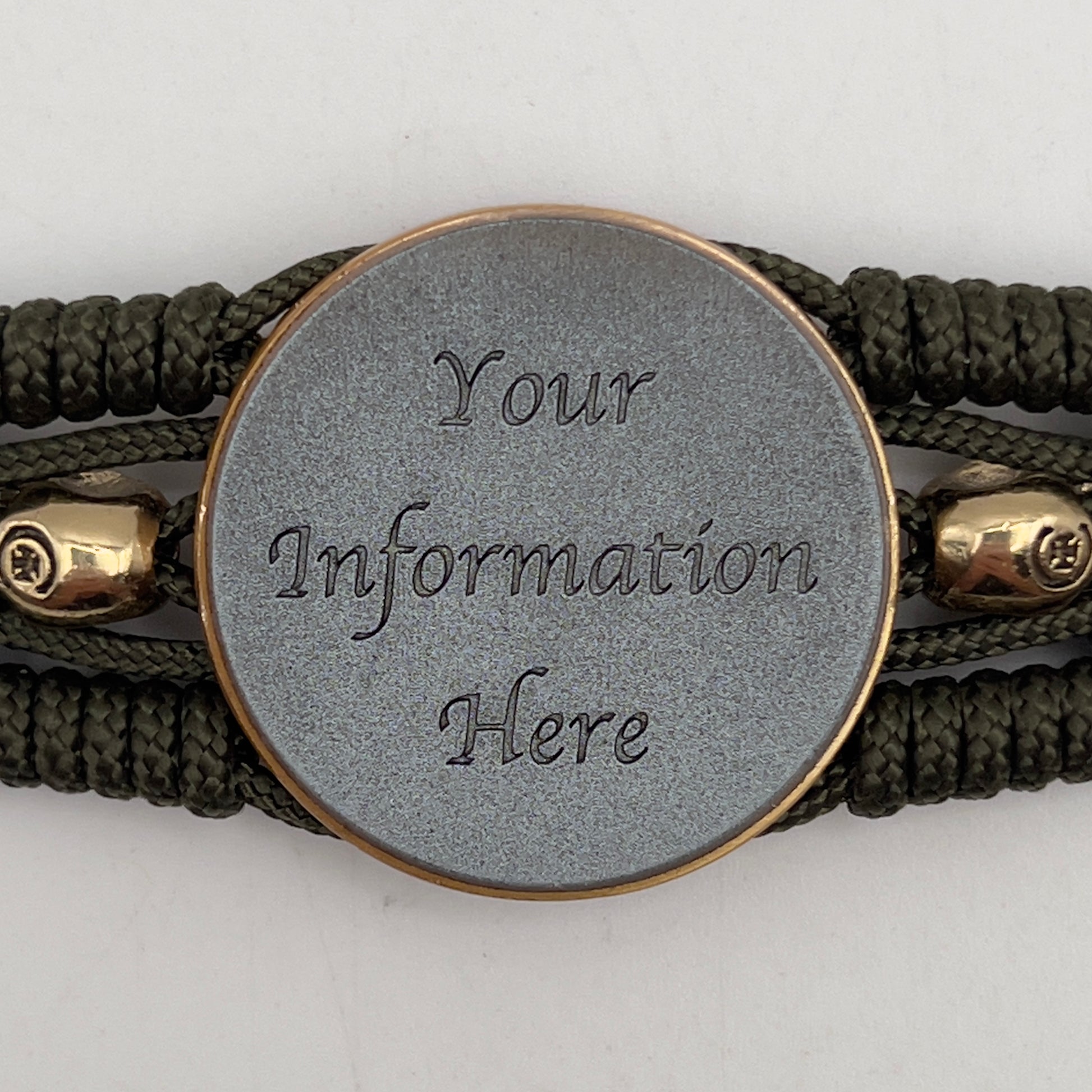 Thin, medium width, flexible and comfortable braided United States Marine Corps bracelet featuring a 24K antique gold plated USMC officer Eagle Globe and Anchor medallion, two gold plated skulls, a gold Cobra style tactical buckle and woven with Olive Drab Type-1 paracord.