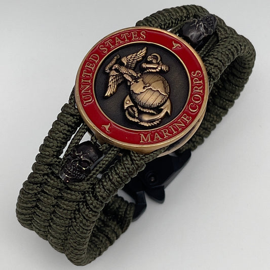 Thin, medium width, flexible and comfortable braided United States Marine Corps bracelet featuring a 24K antique gold plated USMC officer Eagle Globe and Anchor medallion, two black skulls, a black Cobra style tactical buckle and woven with Olive Drab Type-1 paracord.
