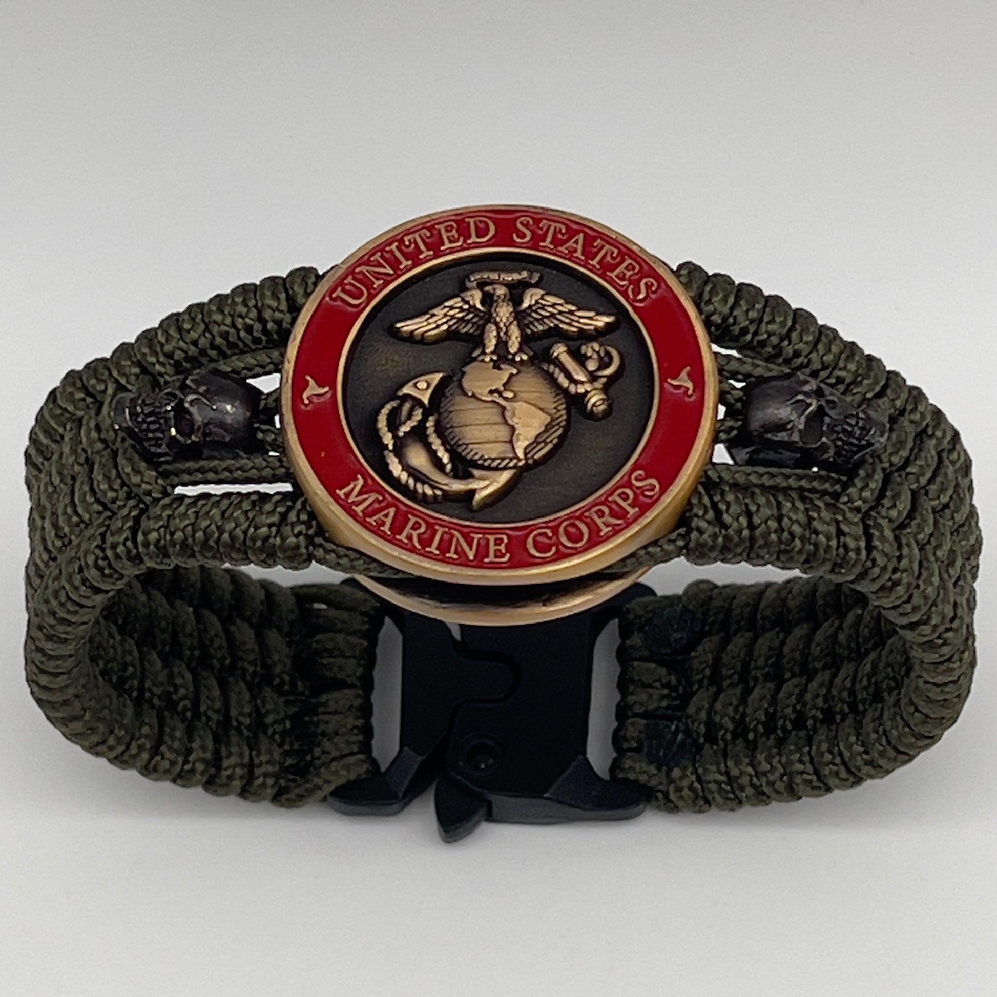 Thin, medium width, flexible and comfortable braided United States Marine Corps bracelet featuring a 24K antique gold plated USMC officer Eagle Globe and Anchor medallion, two black skulls, a black Cobra style tactical buckle and woven with Olive Drab Type-1 paracord.