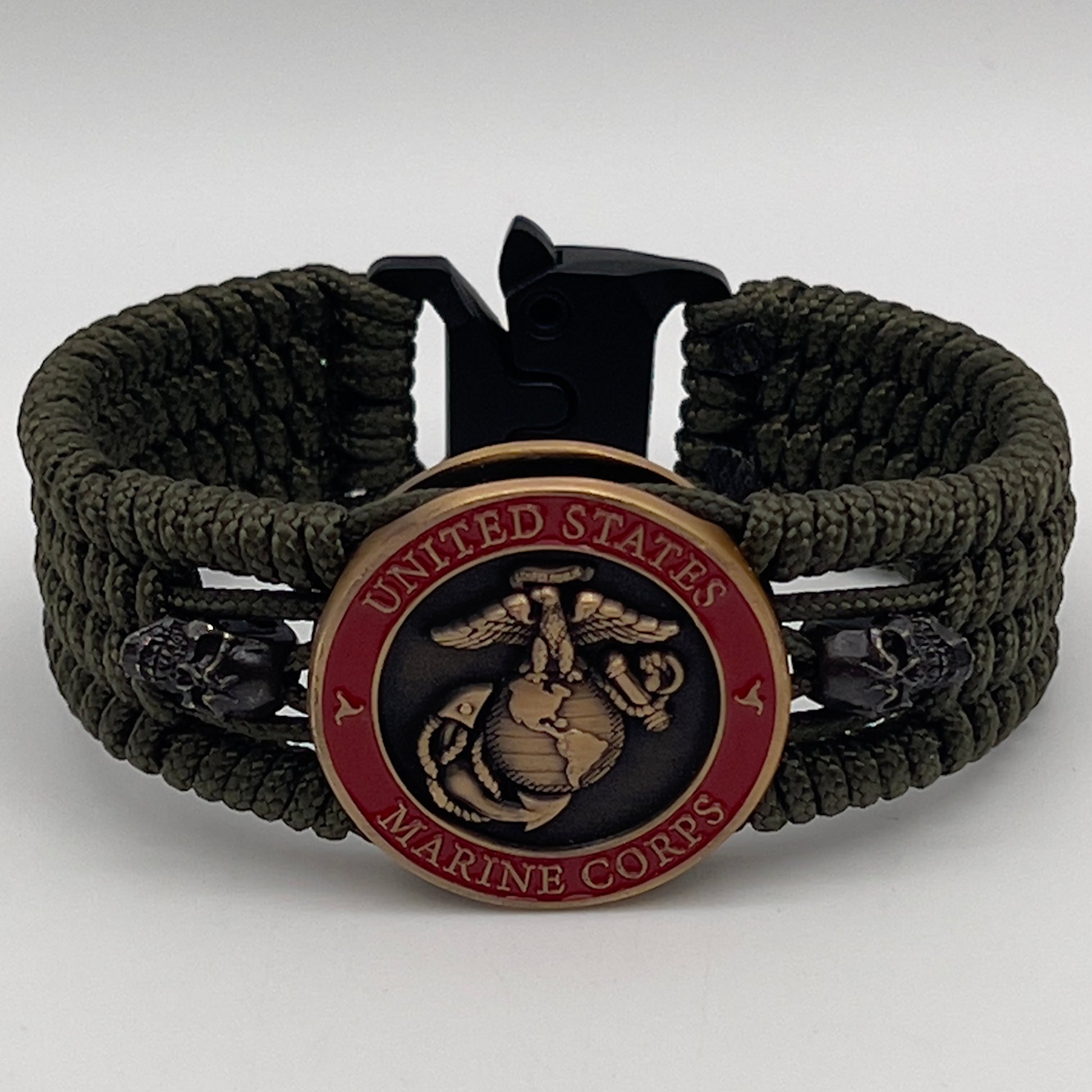 Thin, medium width, flexible and comfortable braided United States Marine Corps bracelet featuring a 24K antique gold plated USMC officer Eagle Globe and Anchor medallion, two black skulls, a black Cobra style tactical buckle and woven with Olive Drab Type-1 paracord.