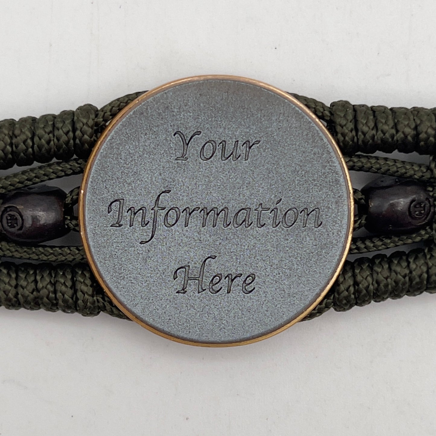 Thin, medium width, flexible and comfortable braided United States Marine Corps bracelet featuring a 24K antique gold plated USMC officer Eagle Globe and Anchor medallion, two black skulls, a black Cobra style tactical buckle and woven with Olive Drab Type-1 paracord.