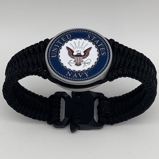 Thin, narrow, flexible and comfortable braided United States Navy bracelet featuring an antique silver plated Navy medallion, a black Cobra style tactical buckle and woven with black Type-1 paracord.