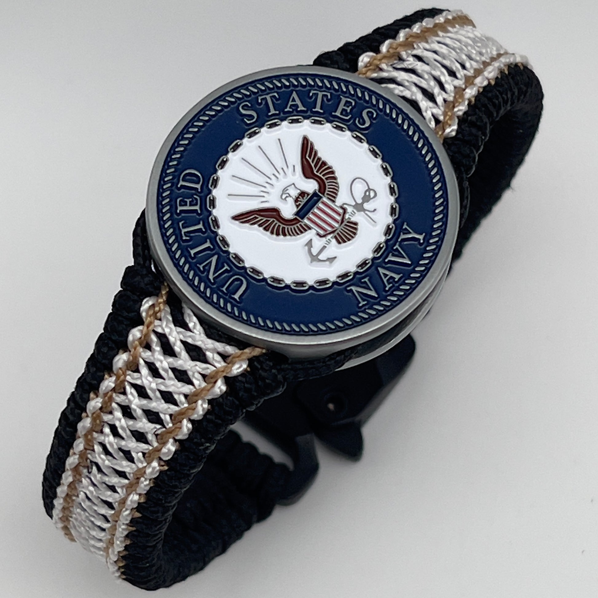 Thin, narrow, flexible and comfortable braided United States Marine Corps bracelet featuring an antique silver plated United States Navy medallion, a black Cobra style tactical buckle and woven with black Type-1 paracord and Gold adn White nano cord.