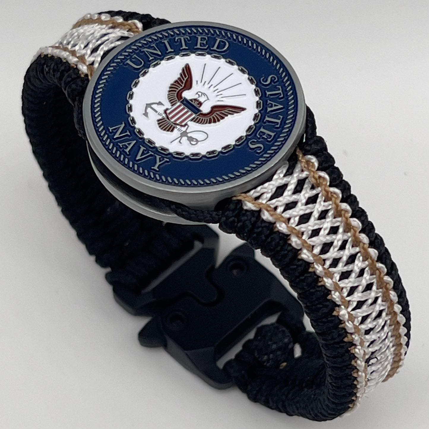 Thin, narrow, flexible and comfortable braided United States Marine Corps bracelet featuring an antique silver plated United States Navy medallion, a black Cobra style tactical buckle and woven with black Type-1 paracord and Gold adn White nano cord.