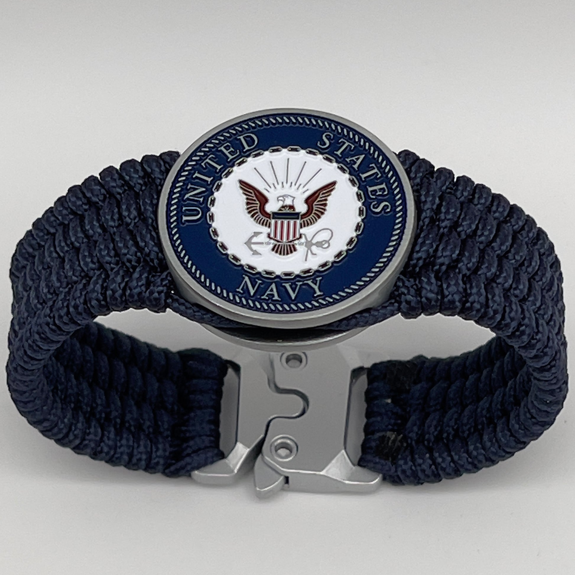 Thin, wide, flexible and comfortable braided United States Navy bracelet featuring an antique silver plated Navy medallion, a black Cobra style tactical buckle and woven with Navy Blue Type-1 paracord.