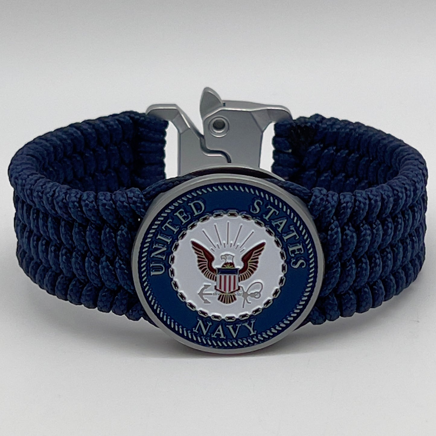Thin, wide, flexible and comfortable braided United States Navy bracelet featuring an antique silver plated Navy medallion, a black Cobra style tactical buckle and woven with Navy Blue Type-1 paracord.