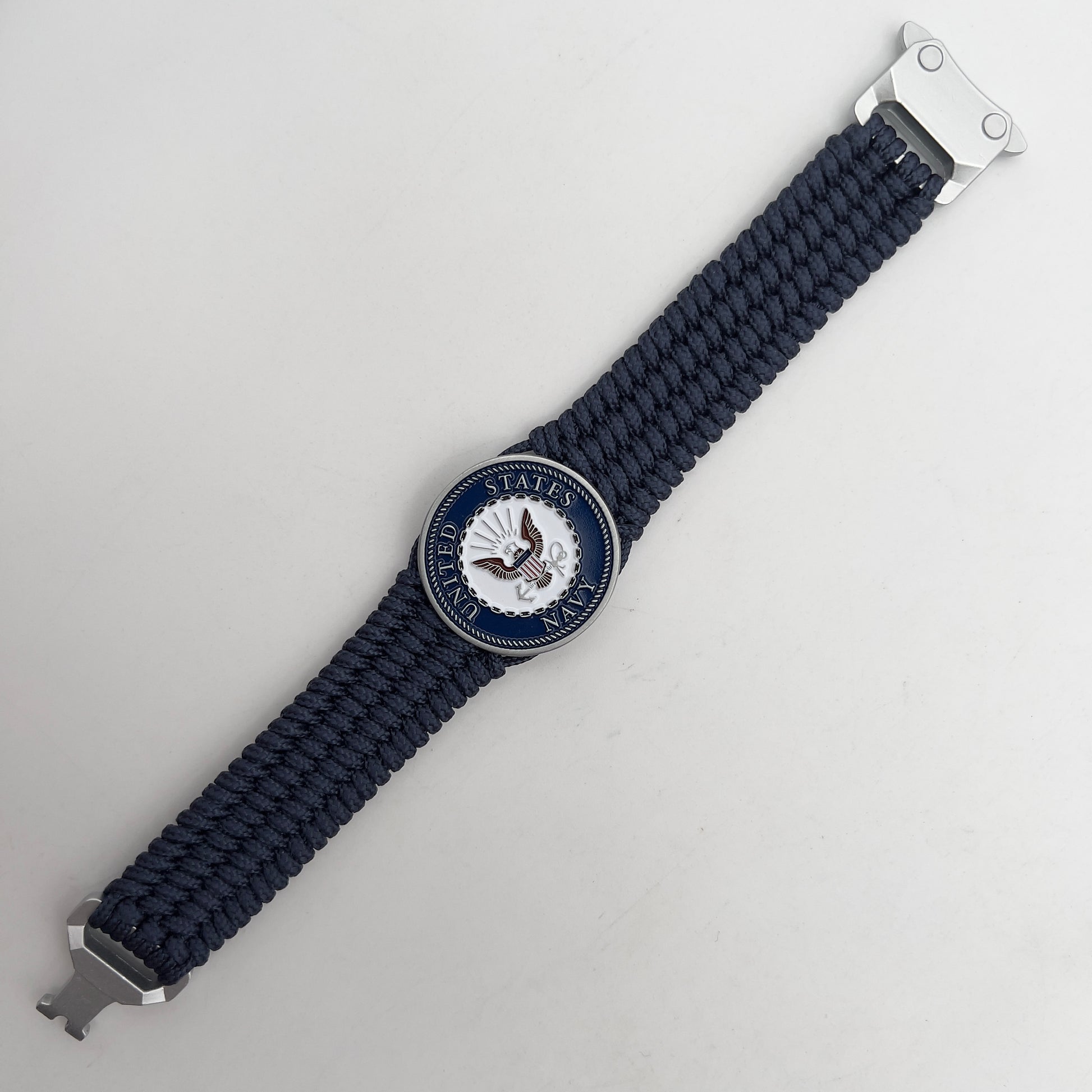 Thin, wide, flexible and comfortable braided United States Navy bracelet featuring an antique silver plated Navy medallion, a black Cobra style tactical buckle and woven with Navy Blue Type-1 paracord.