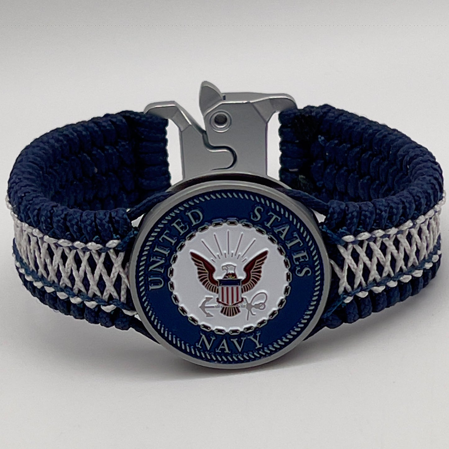 Thin, wide and comfortable braided United States Navy bracelet featuring an antique silver plated Navy medallion, a silver Cobra style tactical buckle and woven with Navy Blue Type-1 paracord and Nay Blue and White nano cord.