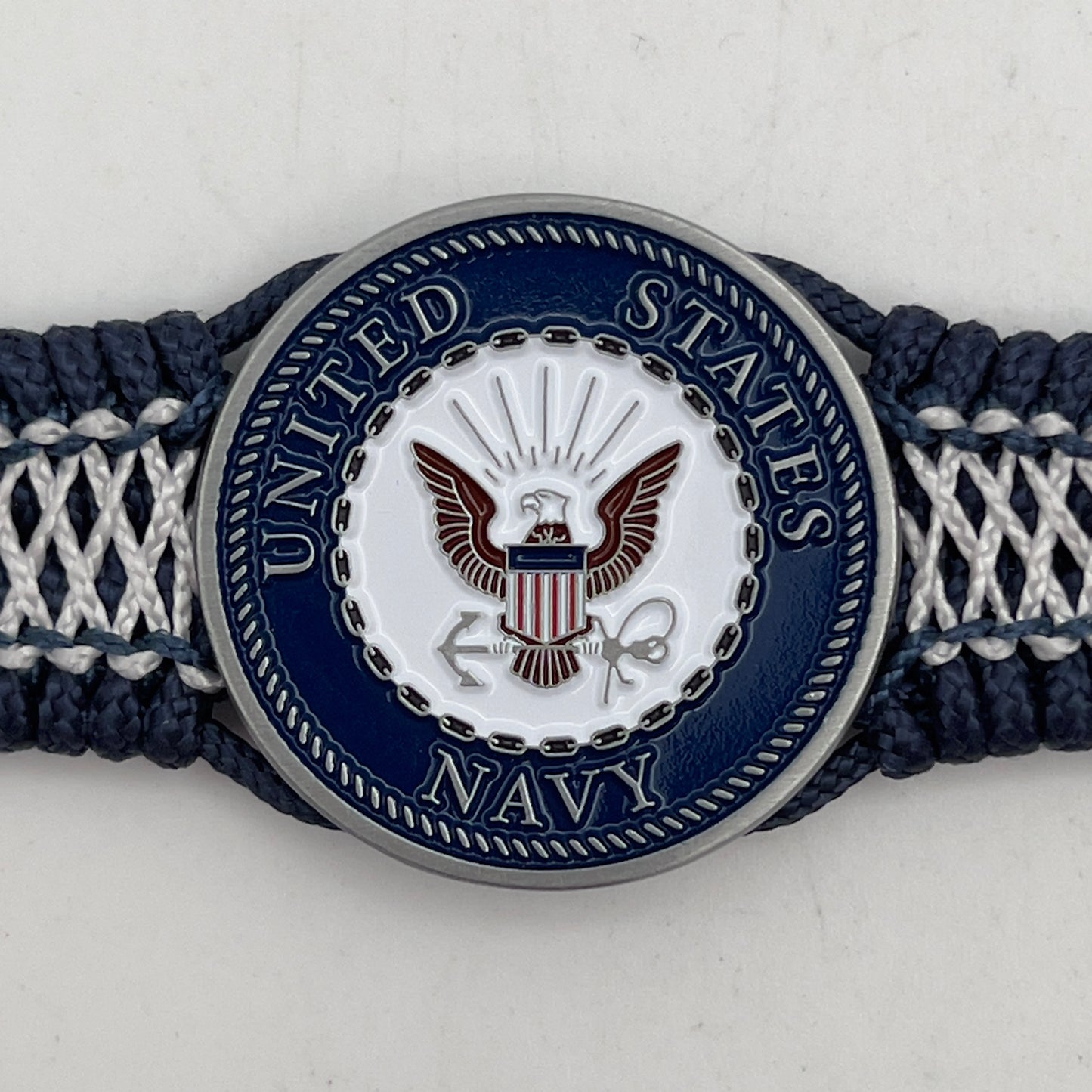 Thin, wide and comfortable braided United States Navy bracelet featuring an antique silver plated Navy medallion, a silver Cobra style tactical buckle and woven with Navy Blue Type-1 paracord and Nay Blue and White nano cord.