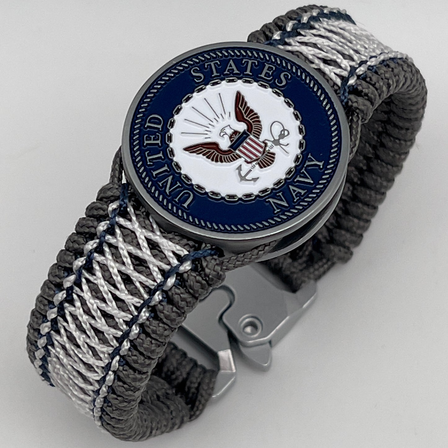 Thin, wide and comfortable braided United States Navy bracelet featuring an antique silver plated Navy medallion, a silver Cobra style tactical buckle and woven with Charcoal Gray Type-1 paracord and Nay Blue and White nano cord.
