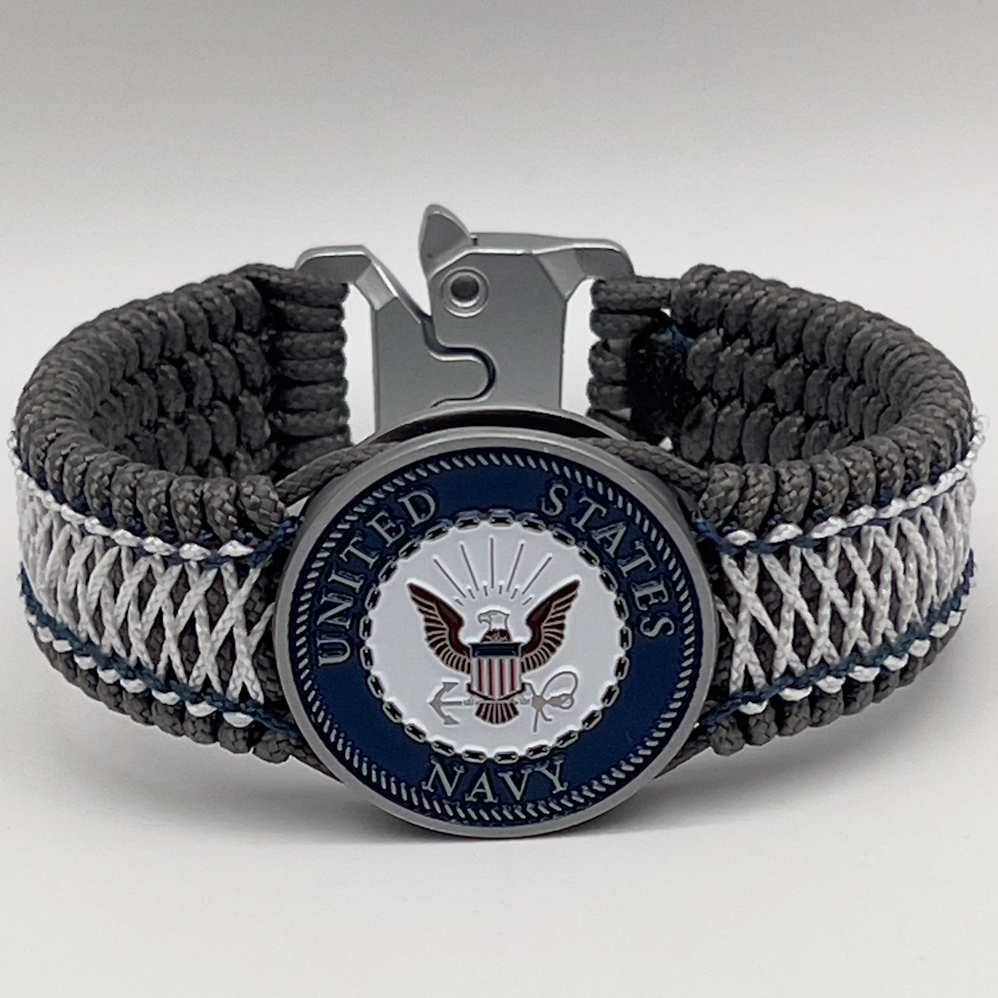 Thin, wide and comfortable braided United States Navy bracelet featuring an antique silver plated Navy medallion, a silver Cobra style tactical buckle and woven with Charcoal Gray Type-1 paracord and Nay Blue and White nano cord.