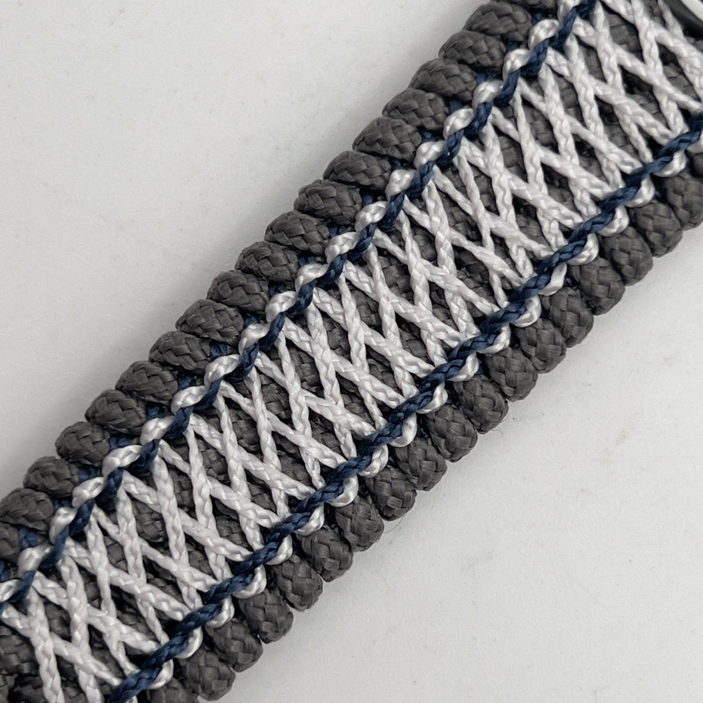 Thin, wide and comfortable braided United States Navy bracelet featuring an antique silver plated Navy medallion, a silver Cobra style tactical buckle and woven with Charcoal Gray Type-1 paracord and Nay Blue and White nano cord.