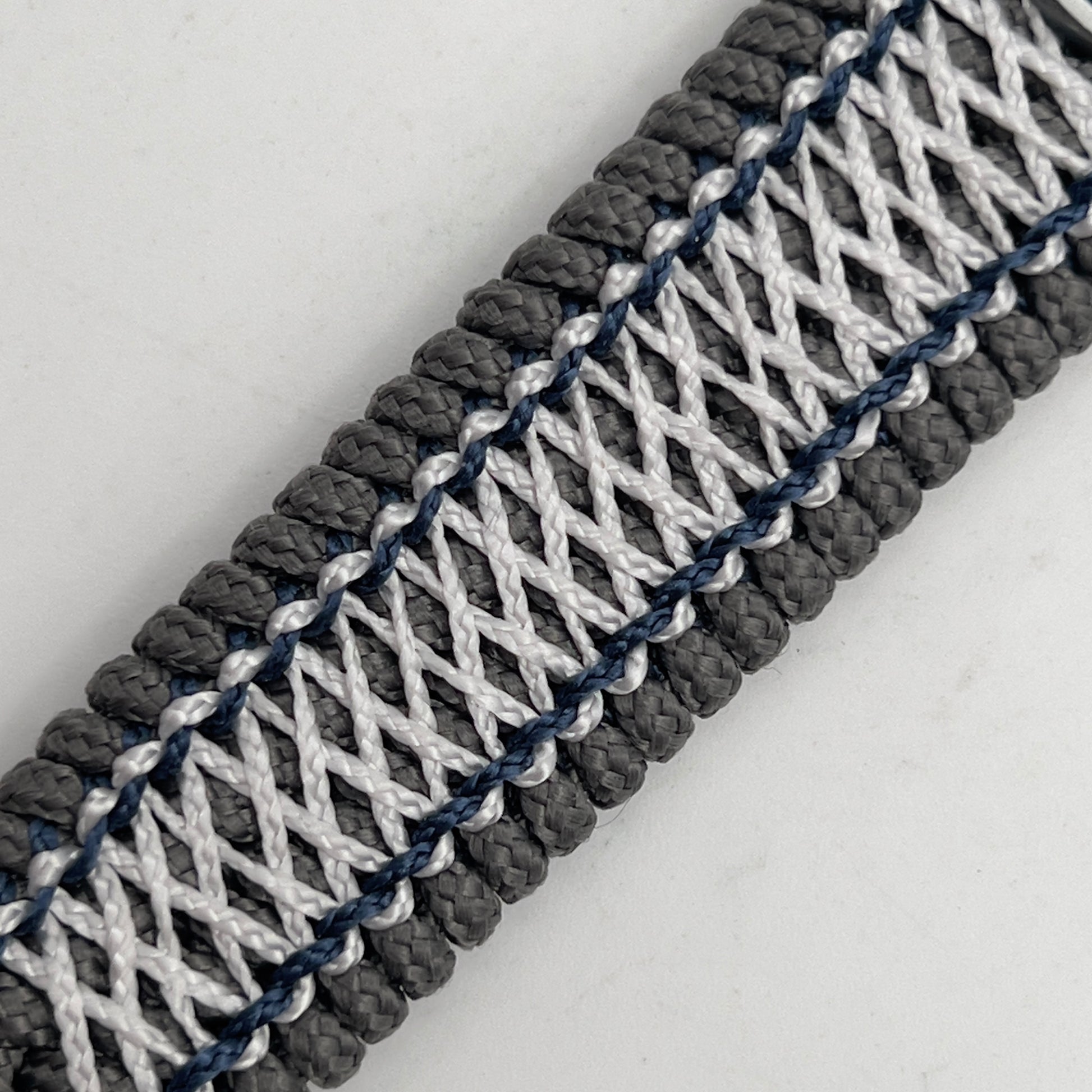 Thin, wide and comfortable braided United States Navy bracelet featuring an antique silver plated Navy medallion, a silver Cobra style tactical buckle and woven with Charcoal Gray Type-1 paracord and Nay Blue and White nano cord.