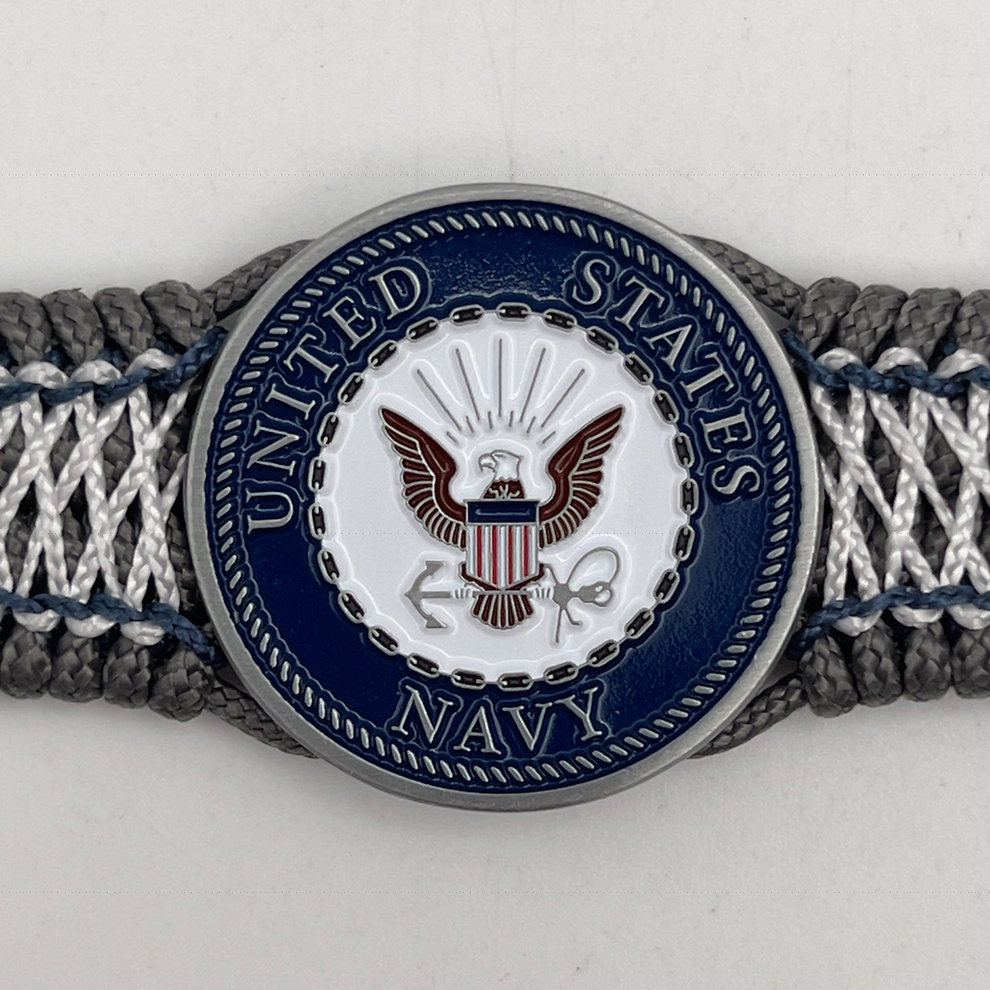 Thin, wide and comfortable braided United States Navy bracelet featuring an antique silver plated Navy medallion, a silver Cobra style tactical buckle and woven with Charcoal Gray Type-1 paracord and Nay Blue and White nano cord.