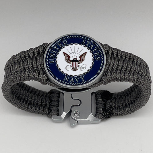 Thin, narrow, flexible and comfortable braided United States Navy bracelet featuring an antique silver plated Navy medallion, a silver Cobra style tactical buckle and woven with Charcoal Gray Type-1 paracord.