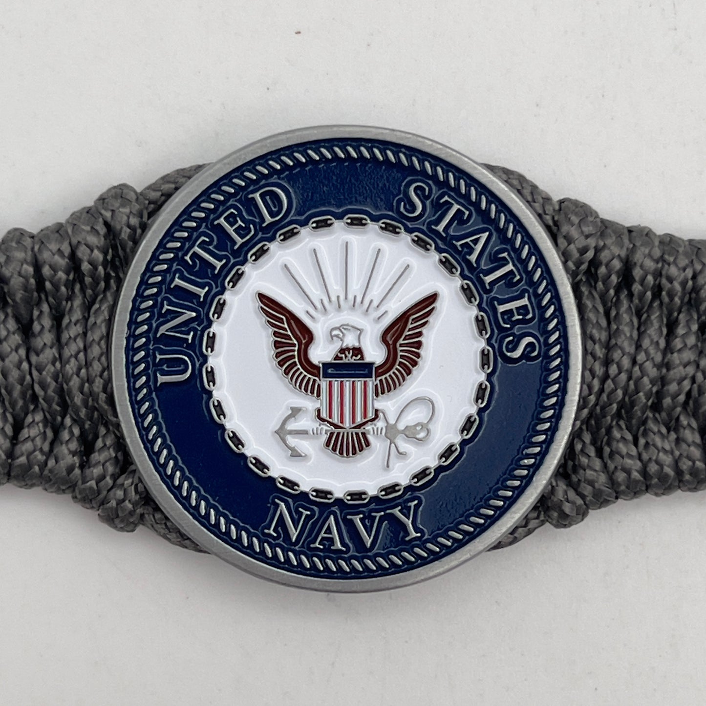 Thin, narrow, flexible and comfortable braided United States Navy bracelet featuring an antique silver plated Navy medallion, a silver Cobra style tactical buckle and woven with Charcoal Gray Type-1 paracord.