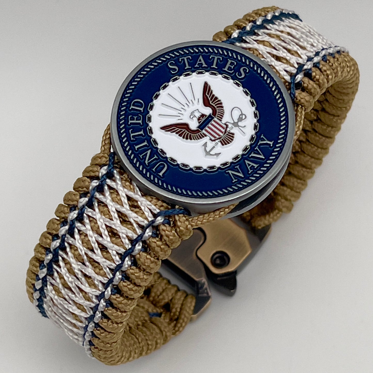 Thin, wide and comfortable braided United States Navy bracelet featuring an antique silver plated Navy medallion, a gold Cobra style tactical buckle and woven with gold Type-1 paracord and Navy Blue and White nano cord.