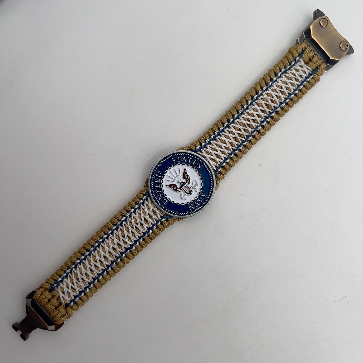 Thin, wide and comfortable braided United States Navy bracelet featuring an antique silver plated Navy medallion, a gold Cobra style tactical buckle and woven with gold Type-1 paracord and Navy Blue and White nano cord.
