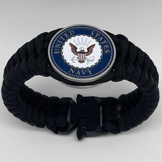 Thick, narrow, and semi-rigid braided United States Navy bracelet featuring an antique silver plated Navy medallion, a black Cobra style tactical buckle and woven with black 550 paracord.