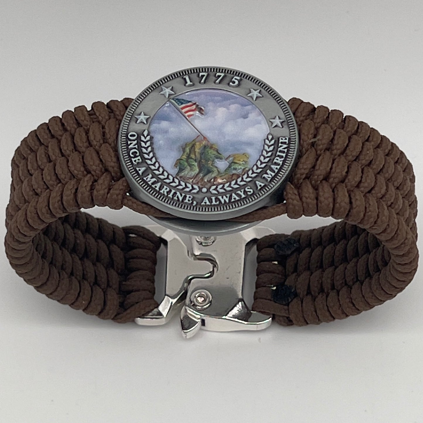 Thin, wide, flexible and comfortable braided United States Marine Corps Iwo Jima bracelet featuring an antique silver plated UV painted Iwo Jima flag raising medallion, a silver Cobra style tactical buckle and woven with Coyote Brown Type-1 paracord.