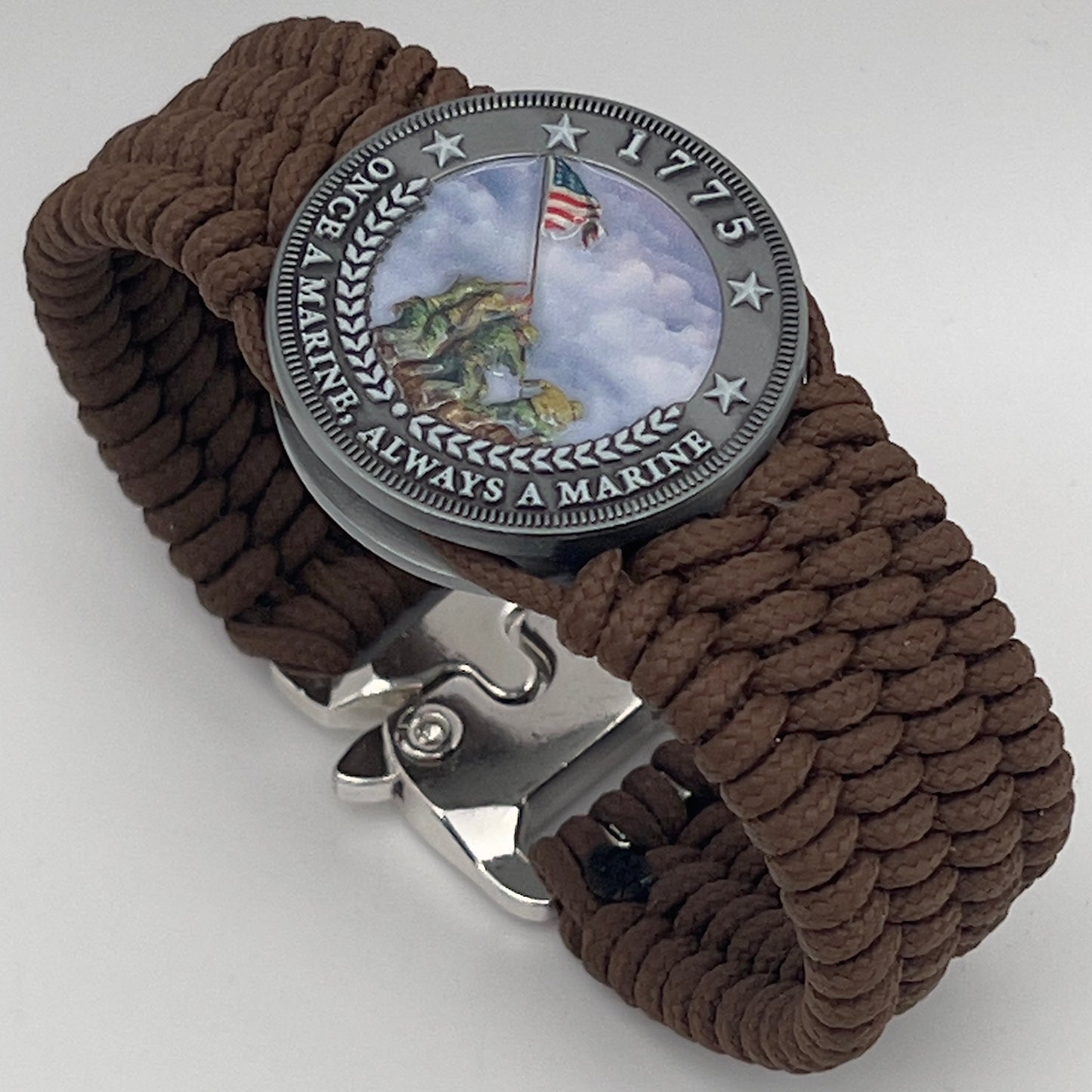 Thin, wide, flexible and comfortable braided United States Marine Corps Iwo Jima bracelet featuring an antique silver plated UV painted Iwo Jima flag raising medallion, a silver Cobra style tactical buckle and woven with Coyote Brown Type-1 paracord.