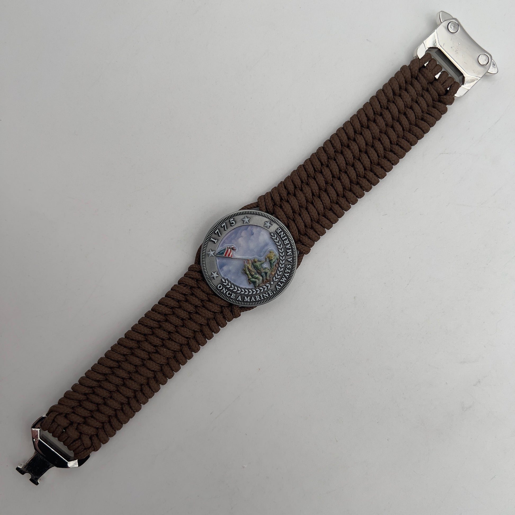 Thin, wide, flexible and comfortable braided United States Marine Corps Iwo Jima bracelet featuring an antique silver plated UV painted Iwo Jima flag raising medallion, a silver Cobra style tactical buckle and woven with Coyote Brown Type-1 paracord.