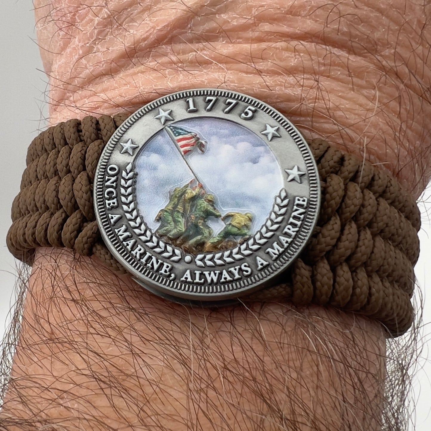 Thin, wide, flexible and comfortable braided United States Marine Corps Iwo Jima bracelet featuring an antique silver plated UV painted Iwo Jima flag raising medallion, a silver Cobra style tactical buckle and woven with Coyote Brown Type-1 paracord.