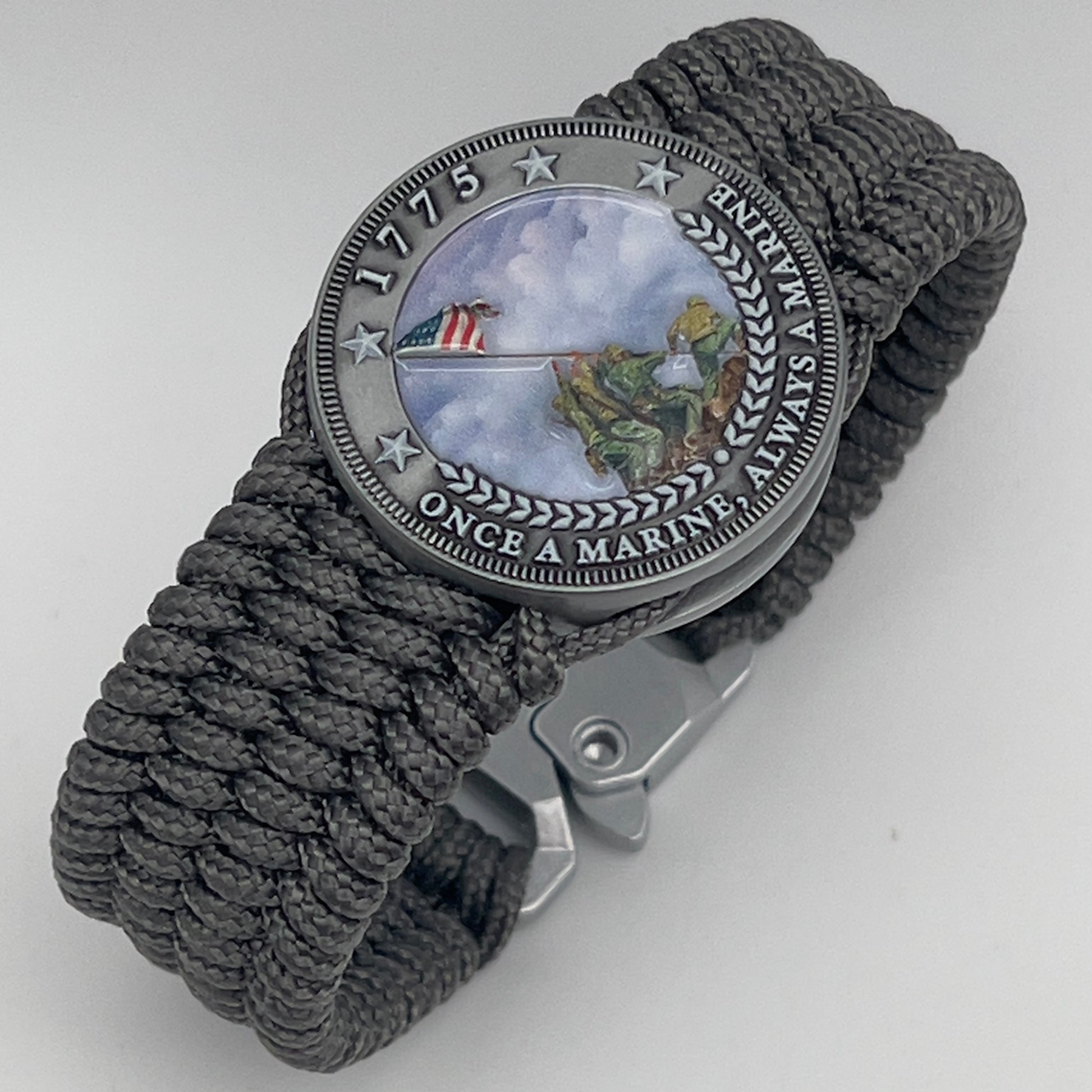 Thin, wide, flexible and comfortable braided United States Marine Corps Iwo Jima bracelet featuring an antique silver plated Iwo Jima flag raising medallion, a silver Cobra style tactical buckle and woven with gray Type-1 paracord.