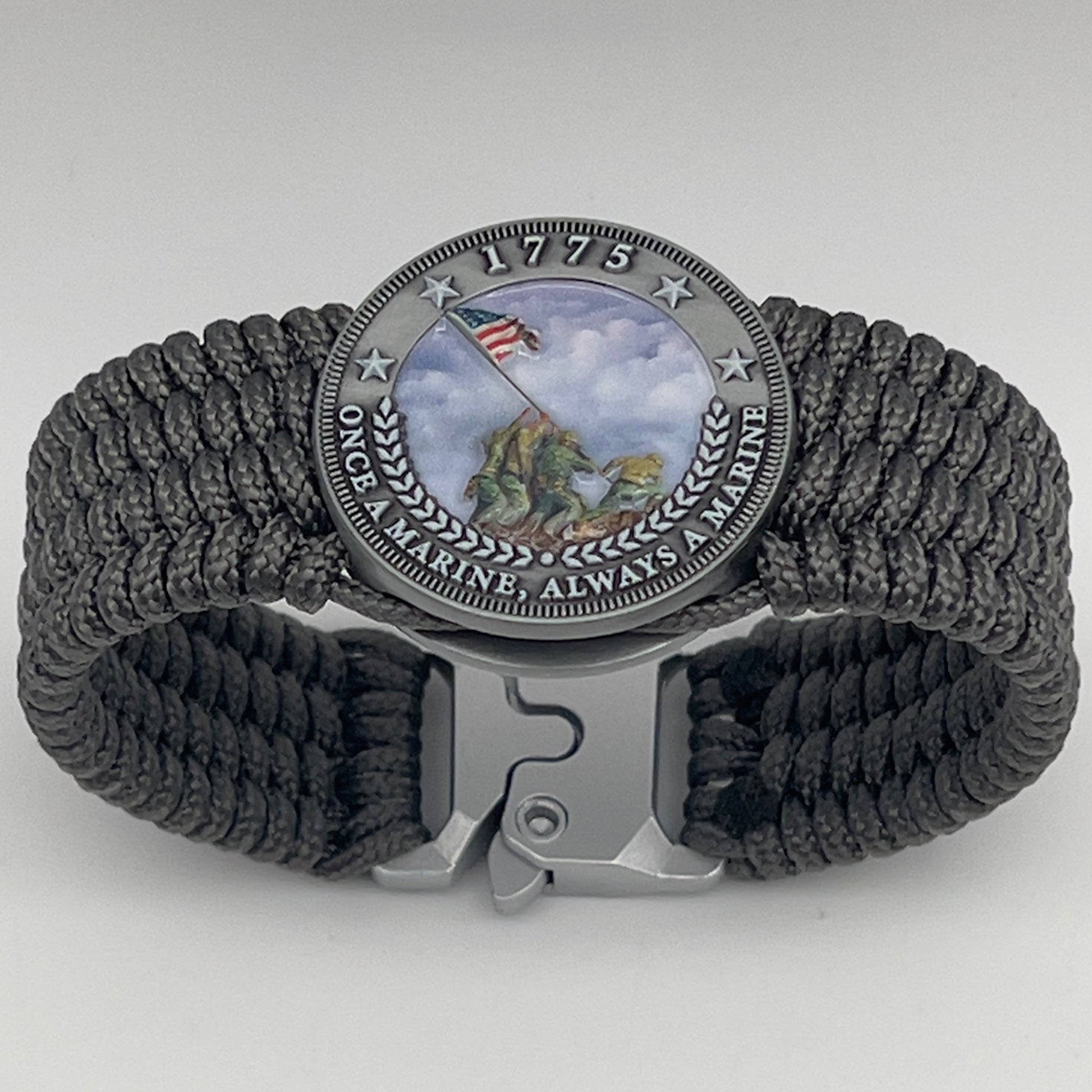 Thin, wide, flexible and comfortable braided United States Marine Corps Iwo Jima bracelet featuring an antique silver plated Iwo Jima flag raising medallion, a silver Cobra style tactical buckle and woven with gray Type-1 paracord.