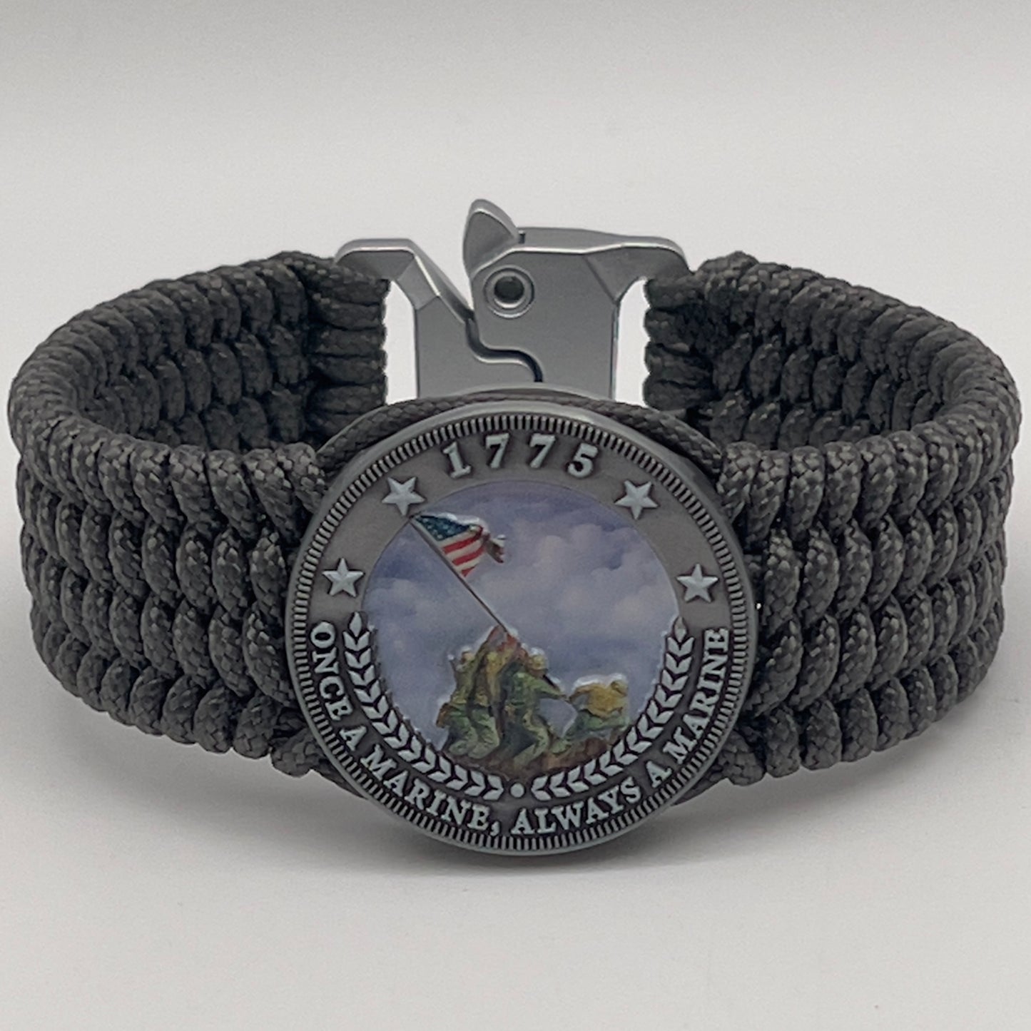 Thin, wide, flexible and comfortable braided United States Marine Corps Iwo Jima bracelet featuring an antique silver plated Iwo Jima flag raising medallion, a silver Cobra style tactical buckle and woven with gray Type-1 paracord.
