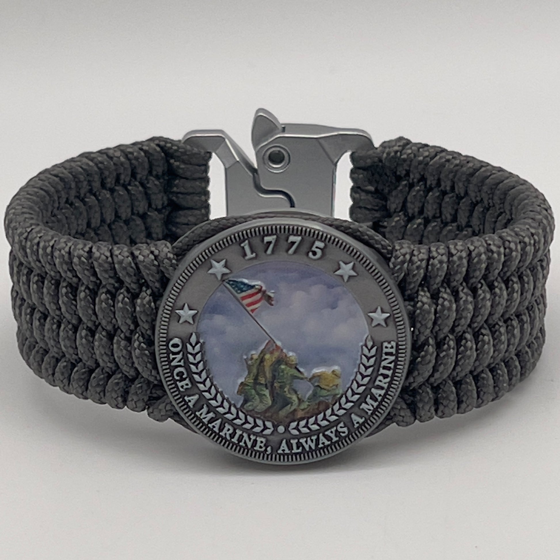 Thin, wide, flexible and comfortable braided United States Marine Corps Iwo Jima bracelet featuring an antique silver plated Iwo Jima flag raising medallion, a silver Cobra style tactical buckle and woven with gray Type-1 paracord.