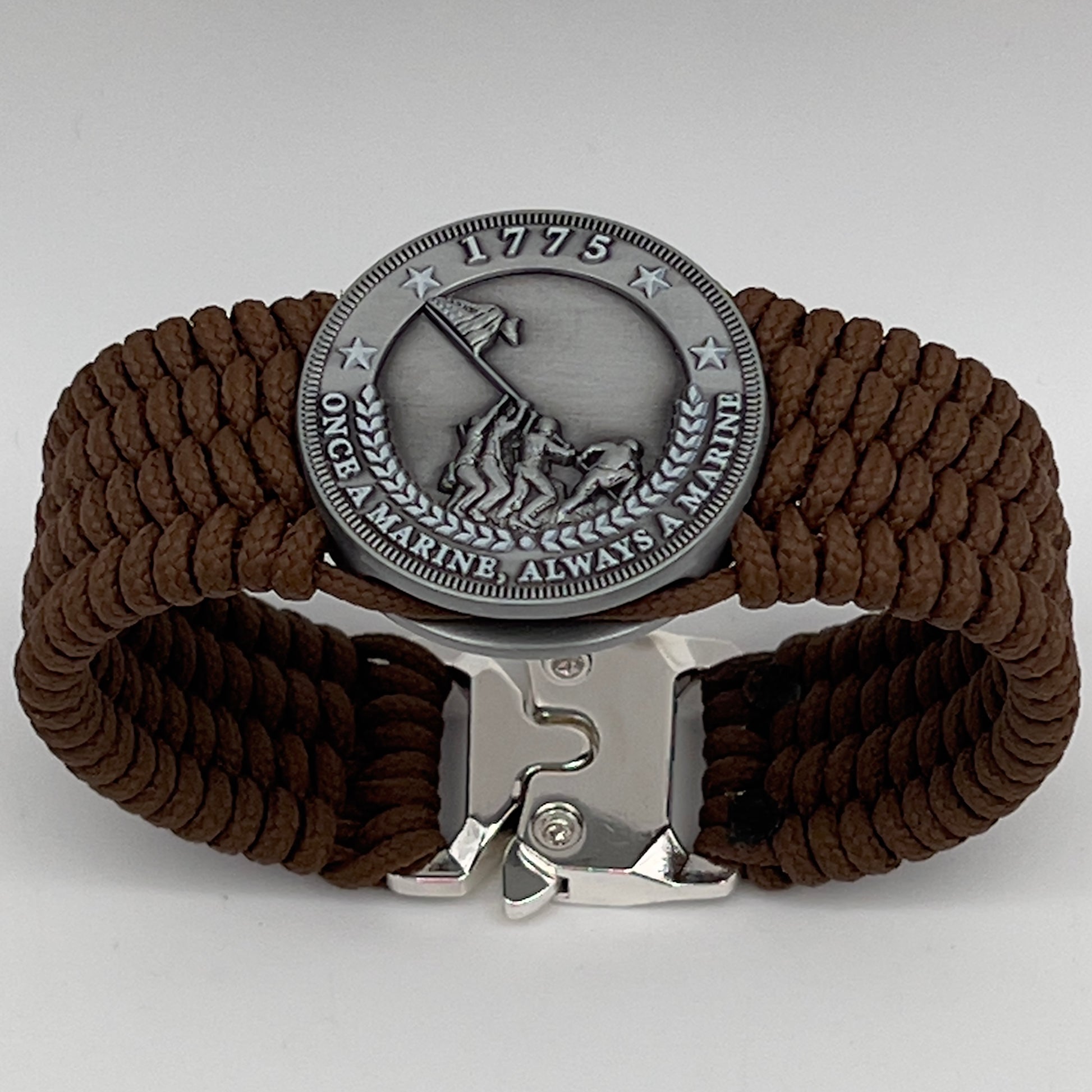 Thin, wide, flexible and comfortable braided United States Marine Corps Iwo Jima bracelet featuring an antique silver plated Iwo Jima flag raising medallion, a silver Cobra style tactical buckle and woven with Coyote Brown Type-1 paracord.