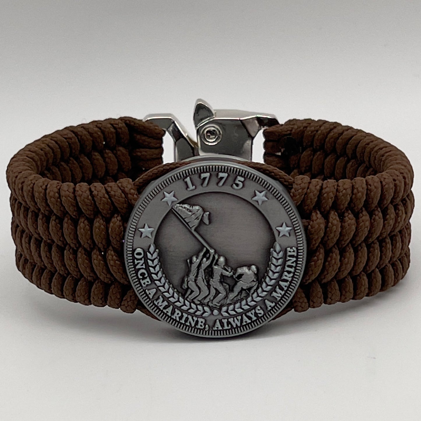 Thin, wide, flexible and comfortable braided United States Marine Corps Iwo Jima bracelet featuring an antique silver plated Iwo Jima flag raising medallion, a silver Cobra style tactical buckle and woven with Coyote Brown Type-1 paracord.