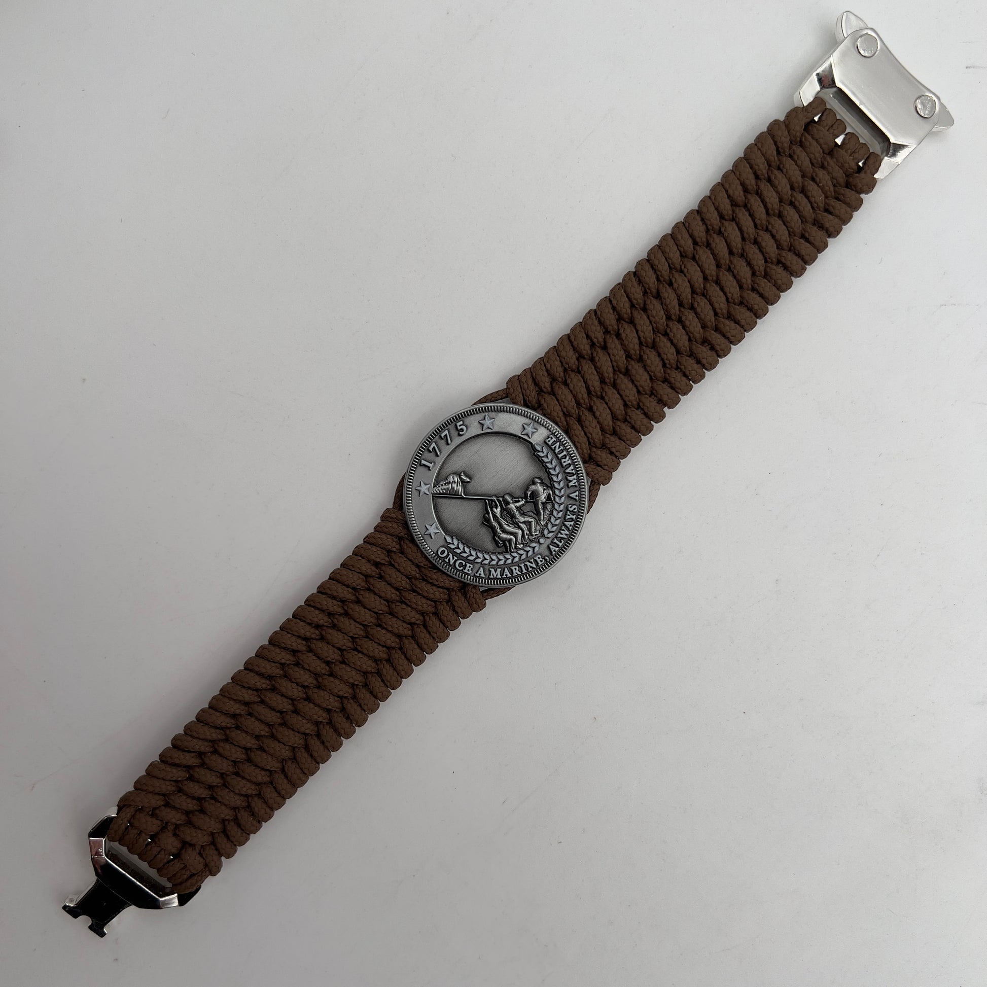 Thin, wide, flexible and comfortable braided United States Marine Corps Iwo Jima bracelet featuring an antique silver plated Iwo Jima flag raising medallion, a silver Cobra style tactical buckle and woven with Coyote Brown Type-1 paracord.